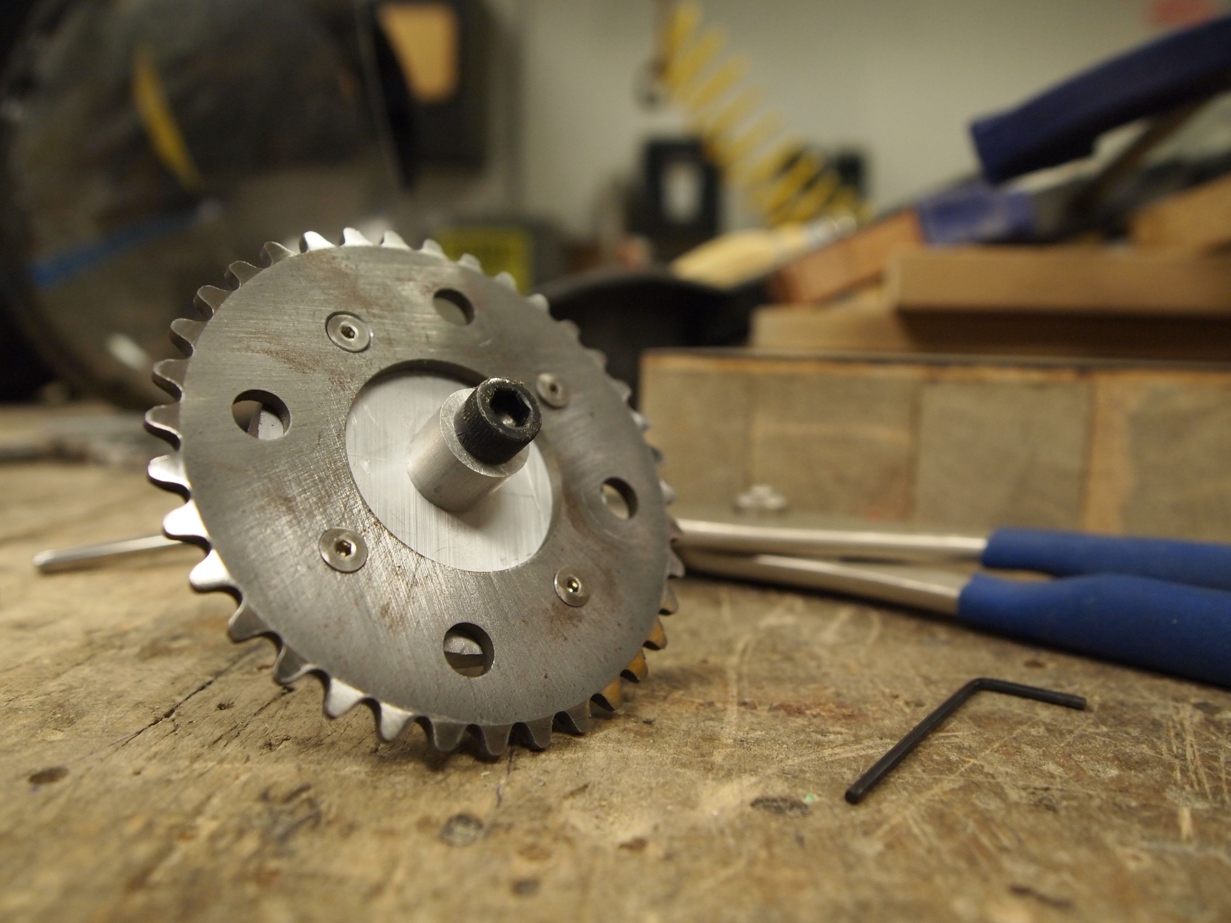 The finished sprocket attached to the arbor I used to hold it in the drill. 