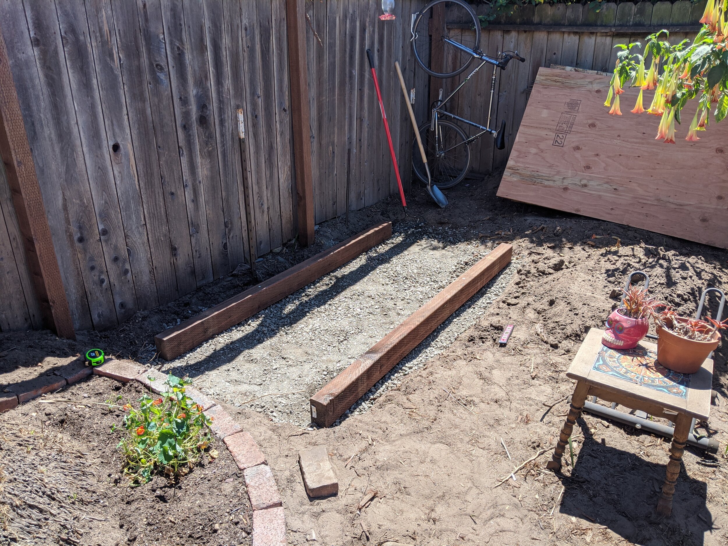  I used many bags of crushed stone as the foundation, which will prevent the shed from sinking over time by allowing rainwater to drain. Once they were in place and leveled, two 8’ pressure-treated 4 x 4s were used to act as a solid base. 