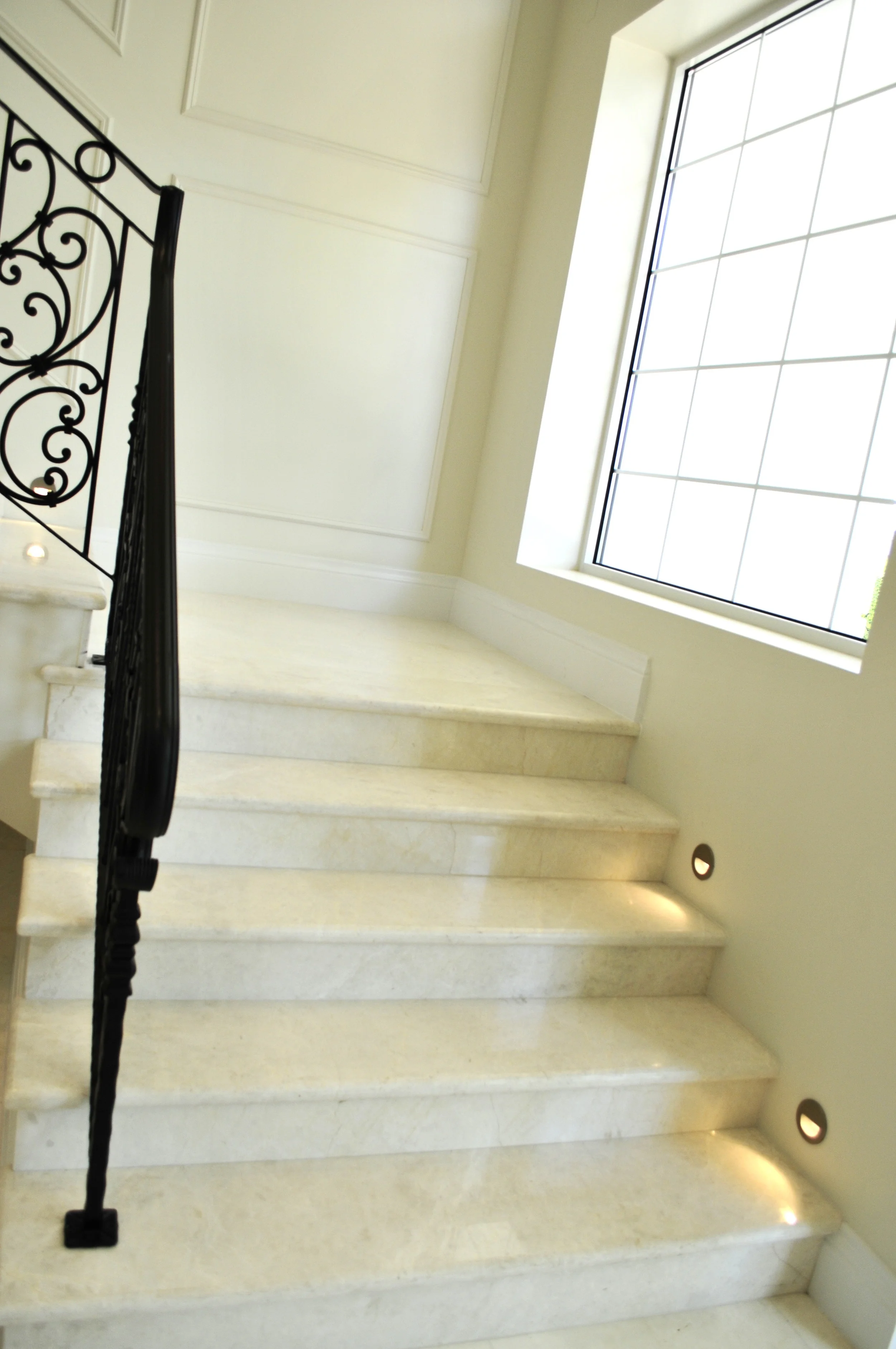 Custom made wrought iron railings made by Artisan Metal works, Marble slab trees and risers, flush mounted low voltage stair lights.jpg