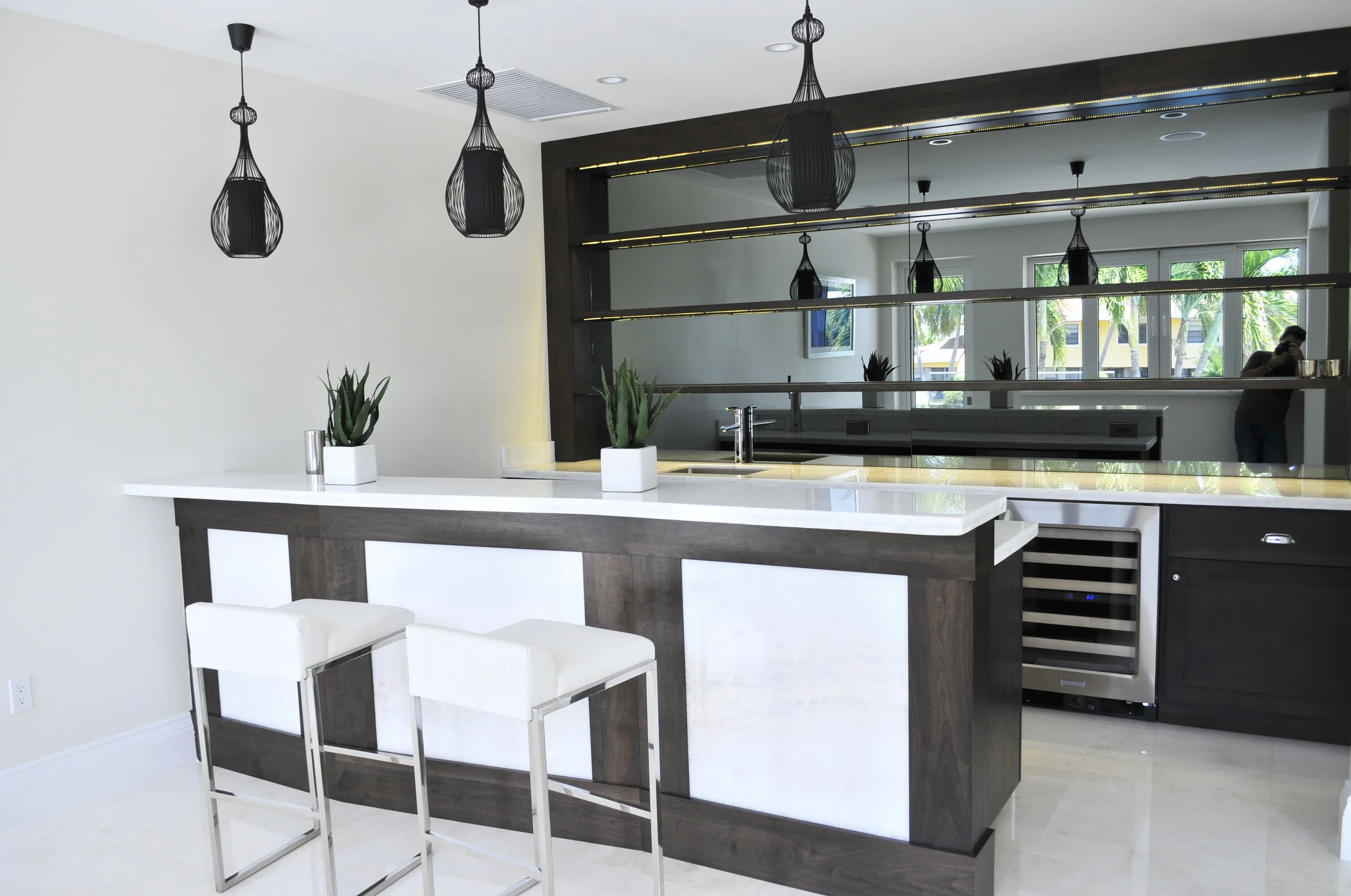 We used a translucent marble for the tops and also incorporated that to the bar front to help break up the heavy tones of the natural walnut..jpg