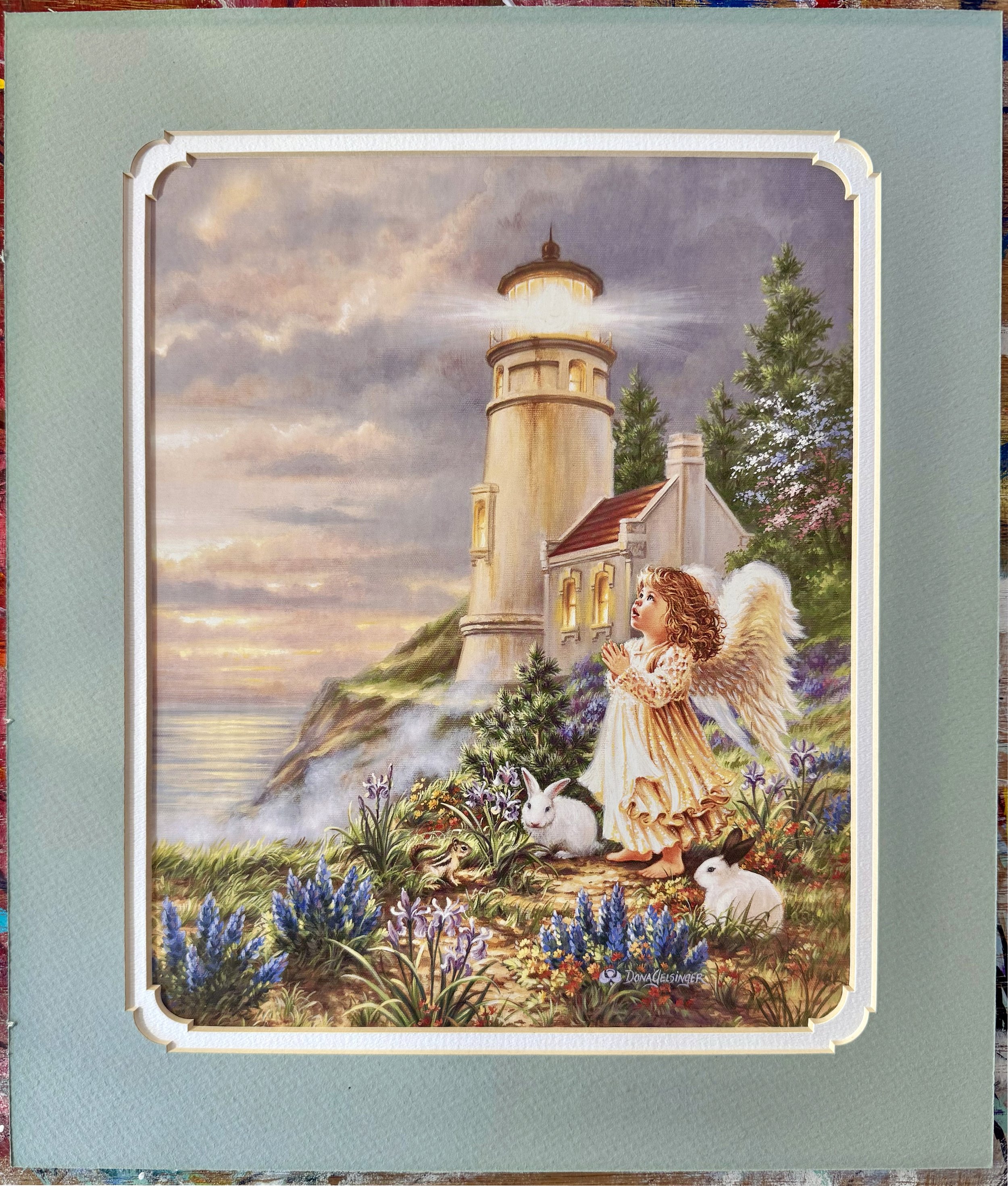 A white angel girl looking up to the sky in prayer in front of an illuminated lighthouse by the shore, surrounded by two rabbits, a chipmunk, and a colorful array of flowers and trees.