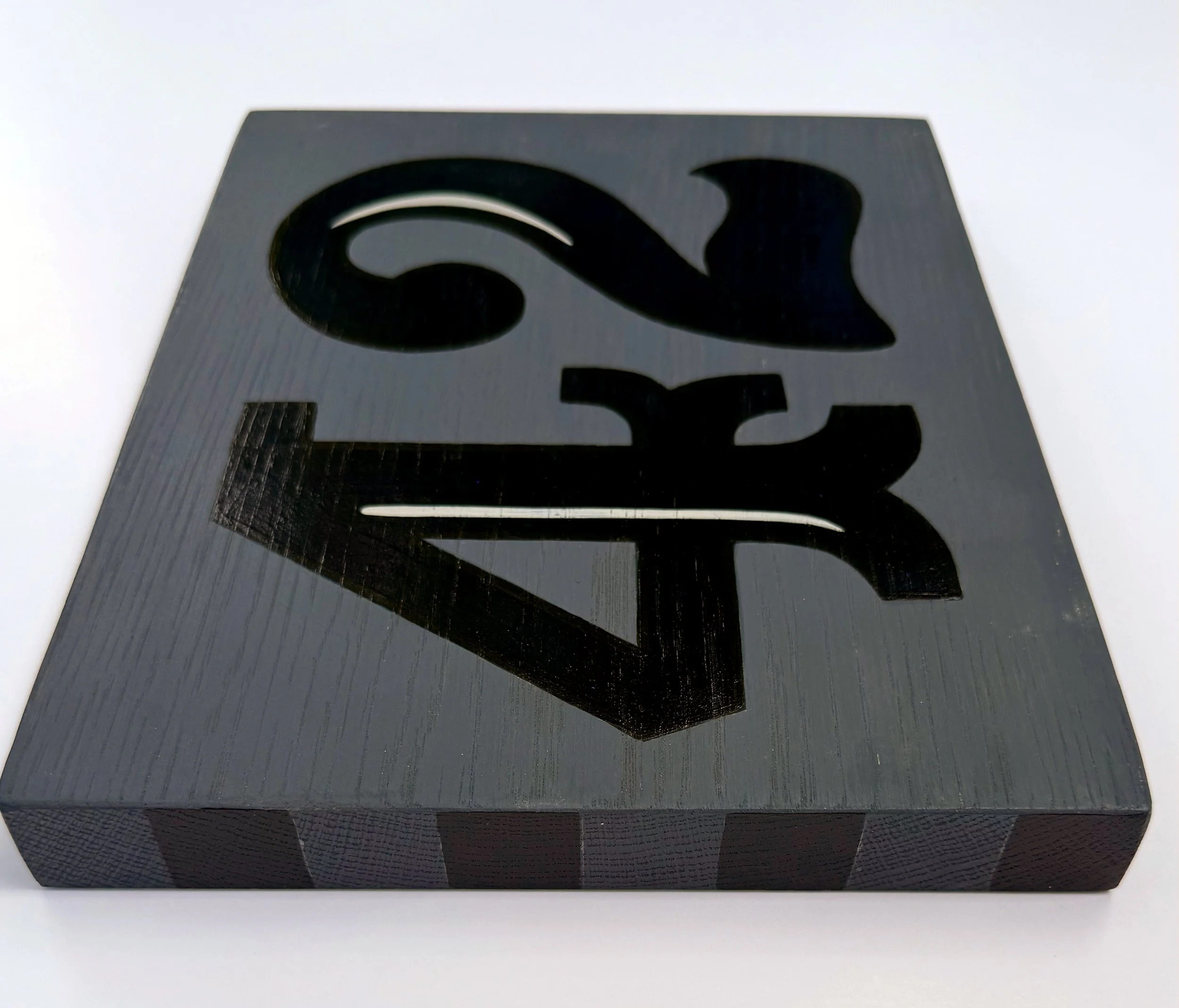 Black and grey stripes on the side of a piece of wood with the number 42 painted on it.