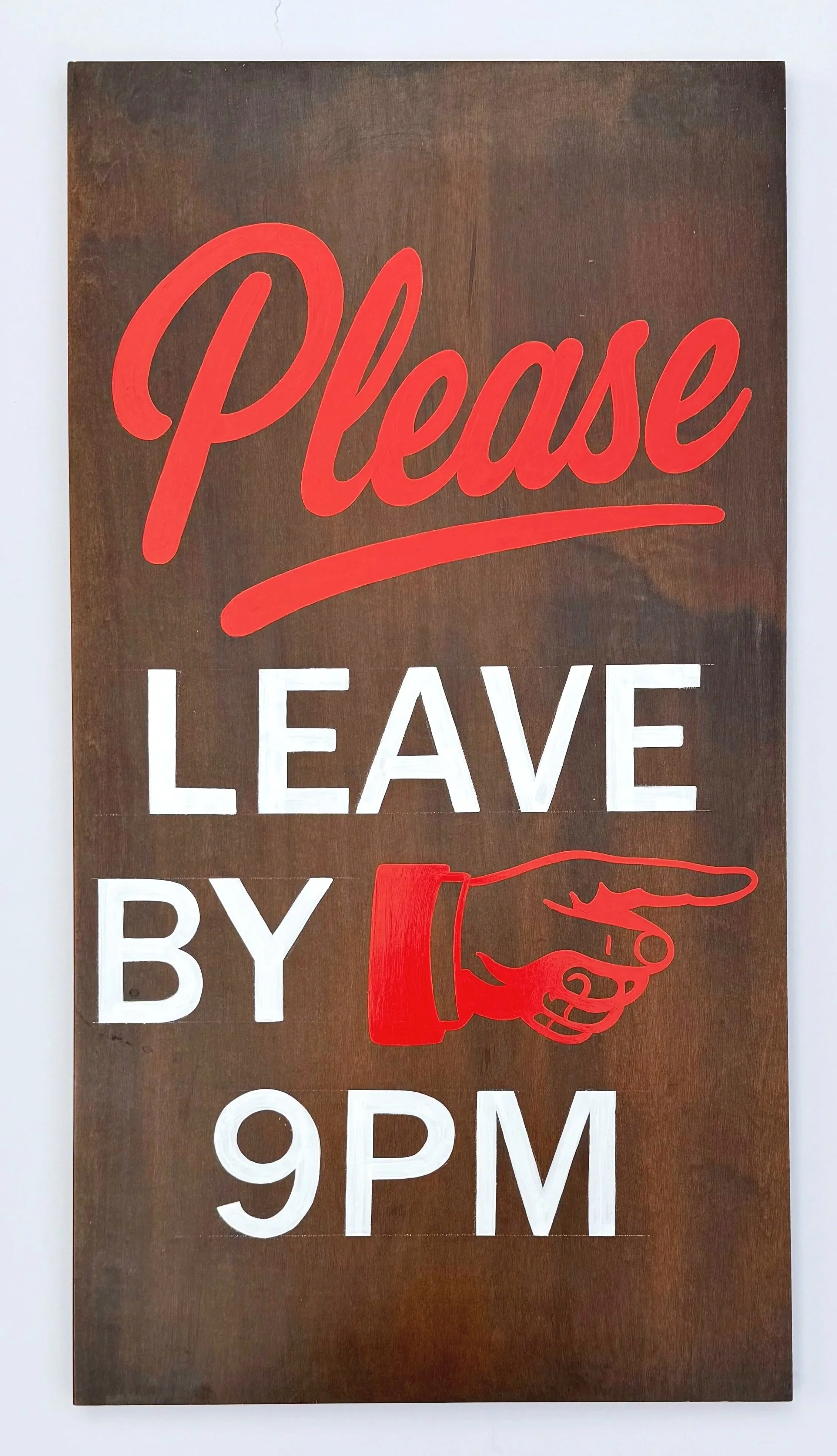 A hand painted sign on a piece of wood that says, Please Leave by 9pm
