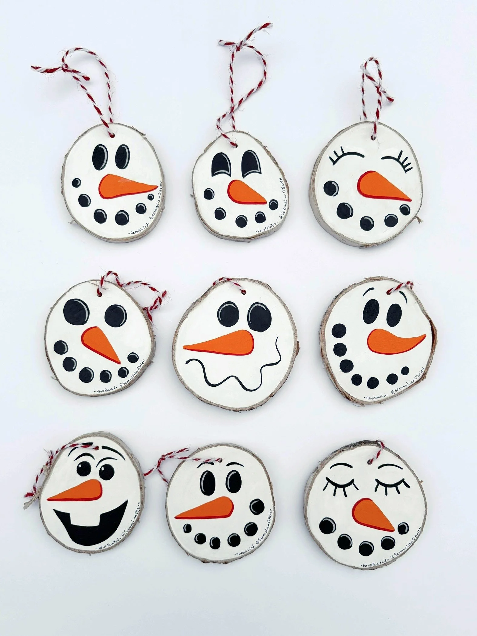 Nine snowman tree ornaments that show various facial expressions