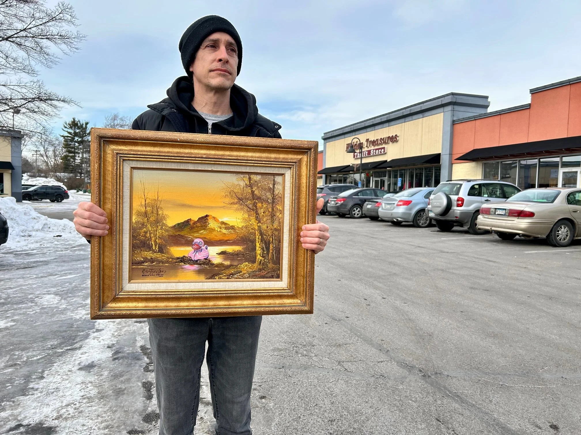 Artist Seamus Liam O'Brien holding his new rubber duck thrift store painting