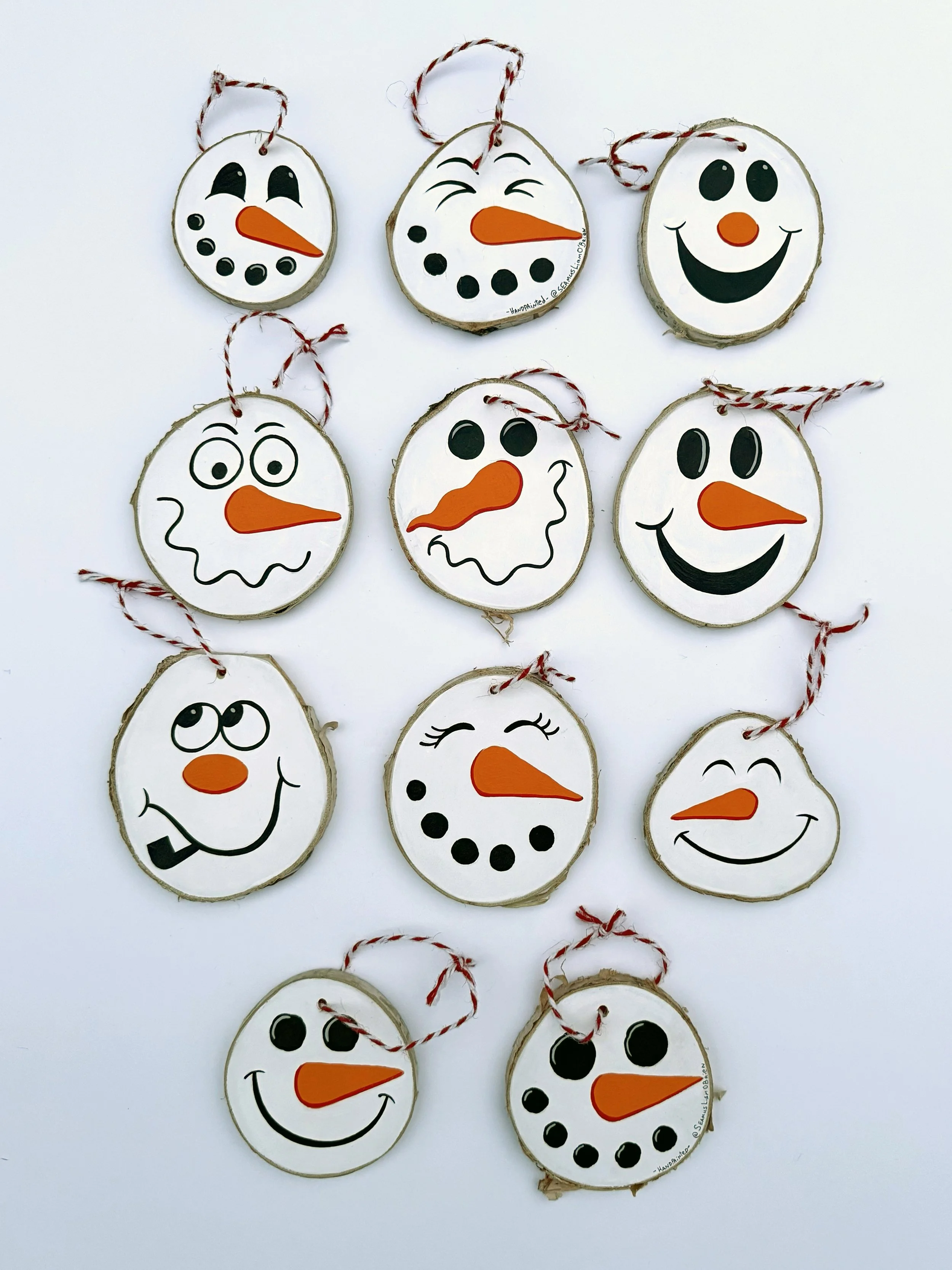Eleven snowman tree ornaments that show various facial expressions
