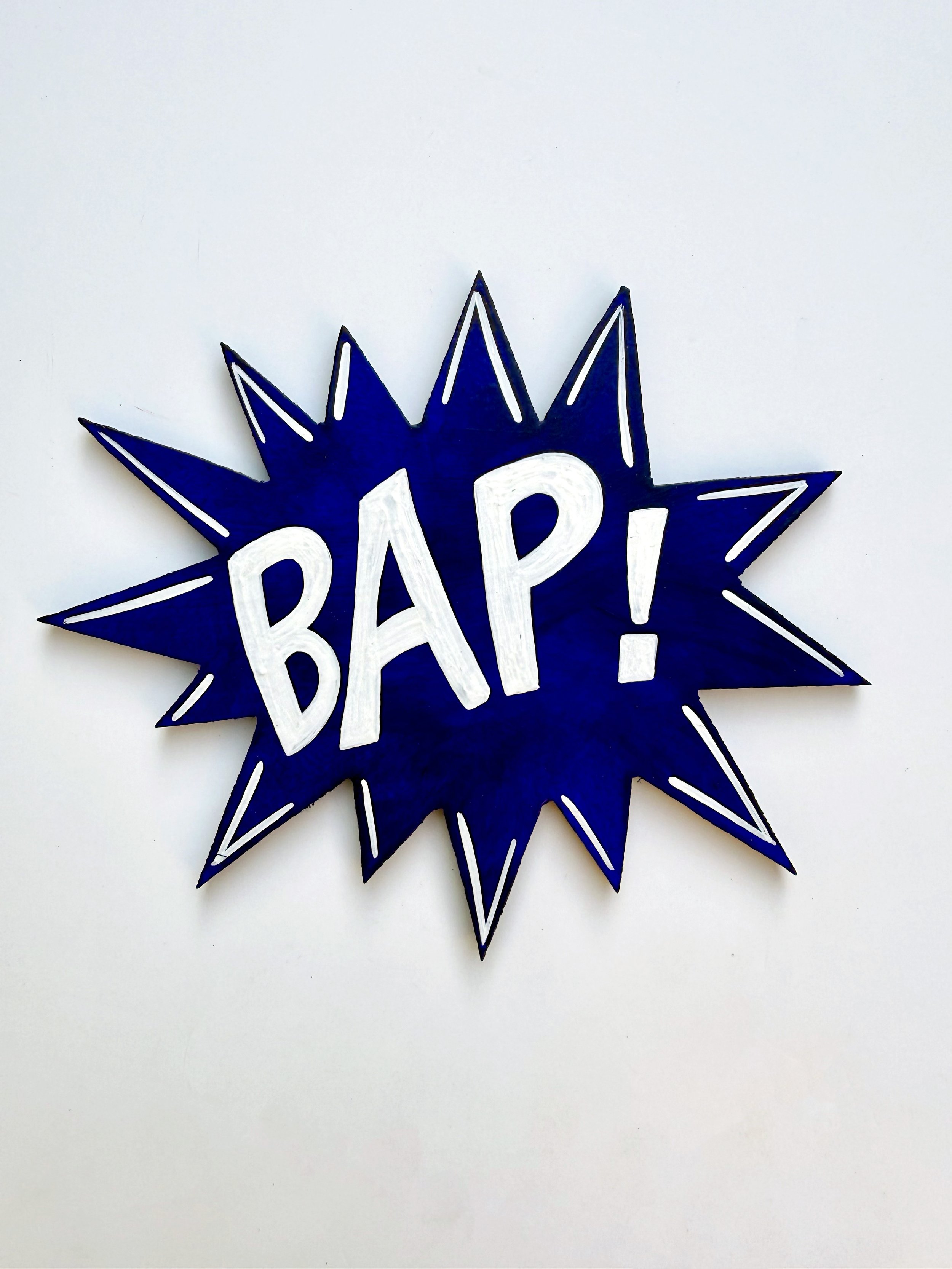 BAP! painted white on a dark blue burst.