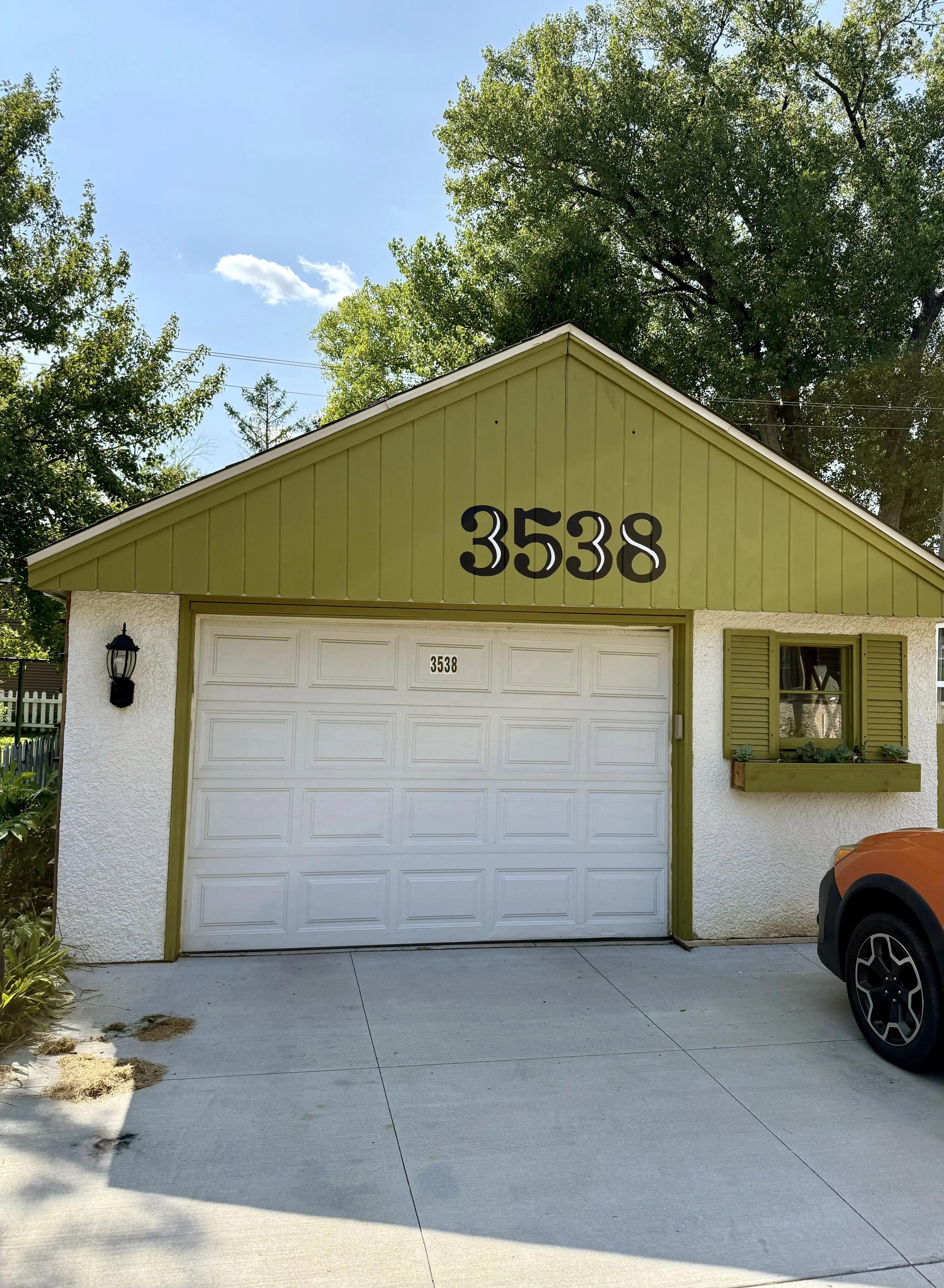 A green white garage with a large 3538 number painted on it.