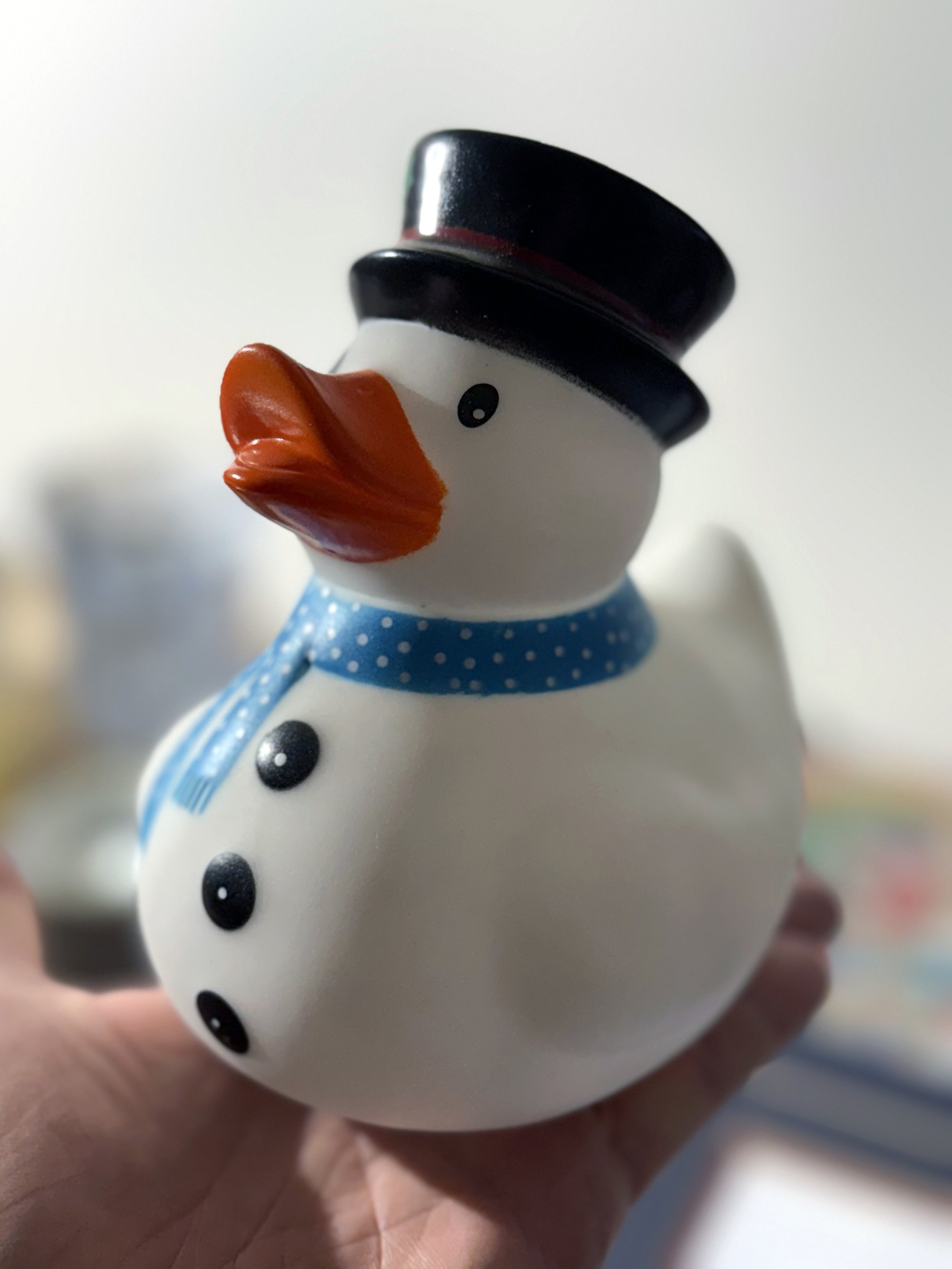 A large, white, snowman themed rubber duck toy