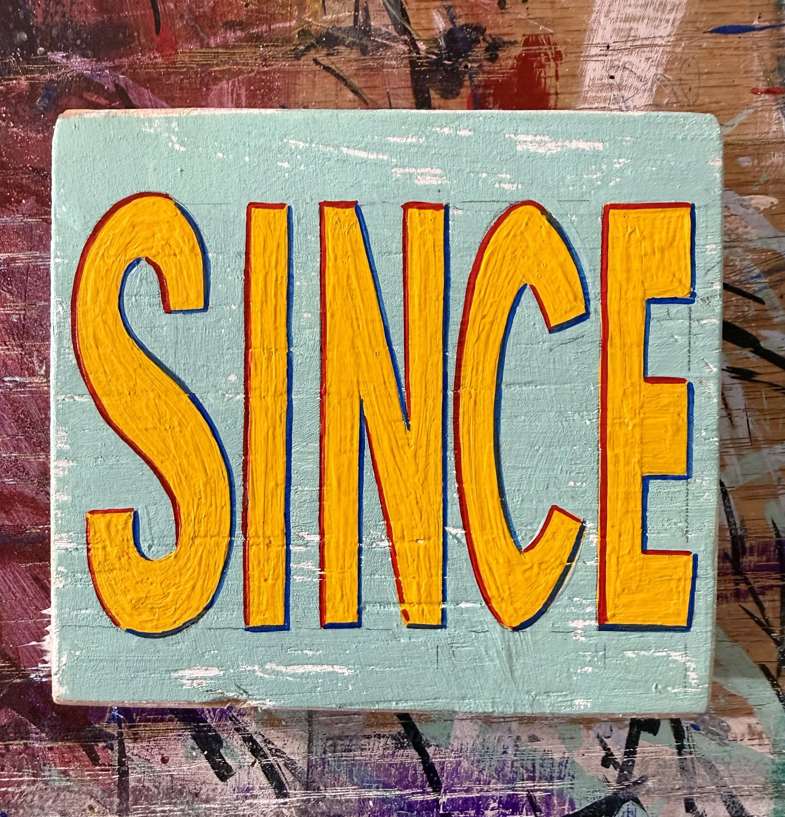 The word, SINCE, painted in yellow letters on a light green piece of wood.