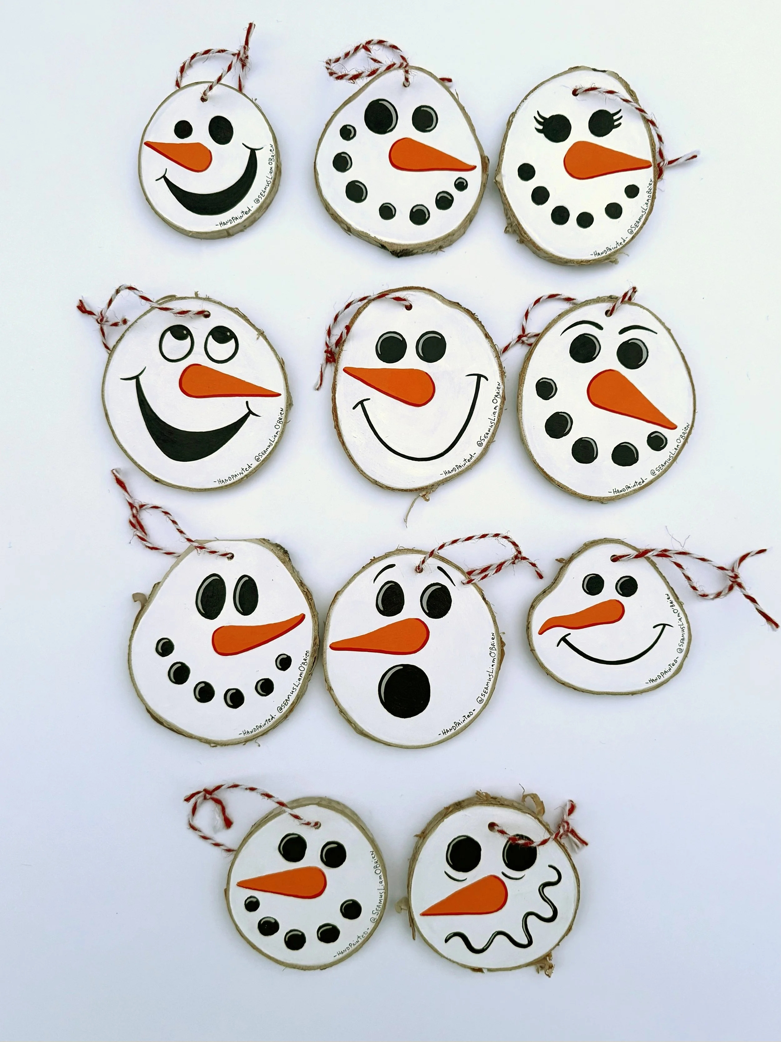 Eleven snowman tree ornaments that show various facial expressions