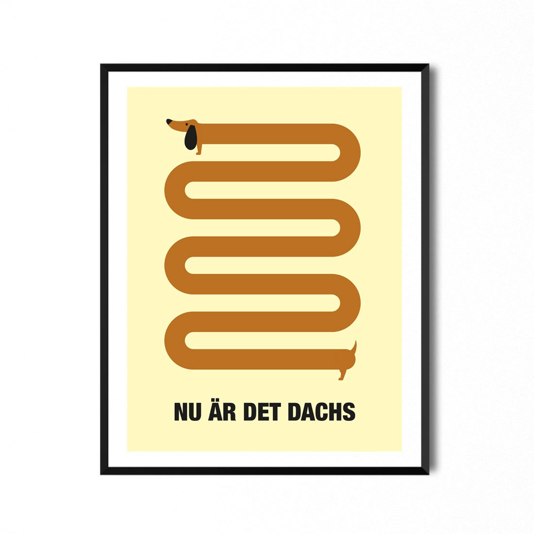 Print av en altfor lang brun dachshund, på gul bakgrunn. Nederst står det skrevet "Nu är det dachs". Opplag på 100, signert og nummerert. Format 30x40 cm - Passer i standard ramme.