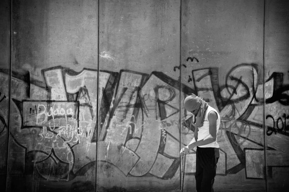  A Palestinian preparing his slingshot, during clashes with the Israeli Police at the Qalandiya checkpoint. 