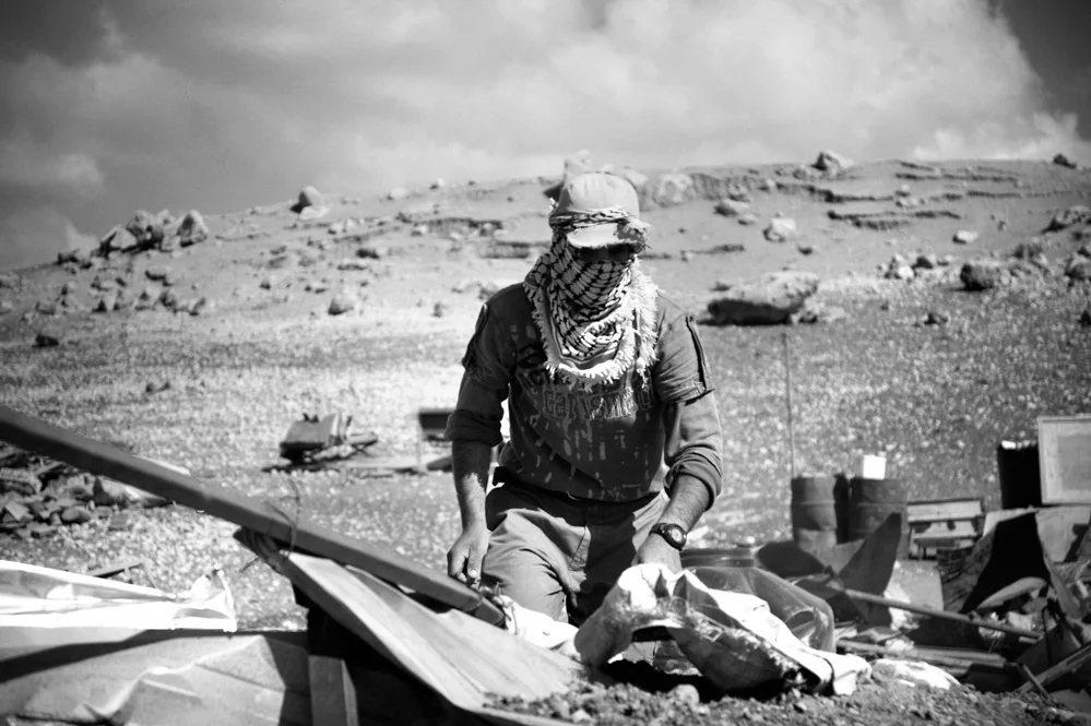  A Bedouin from the Makhul village examine what remain of his house after that it's been demolished by the Israeli Army. Jordan Valley. 