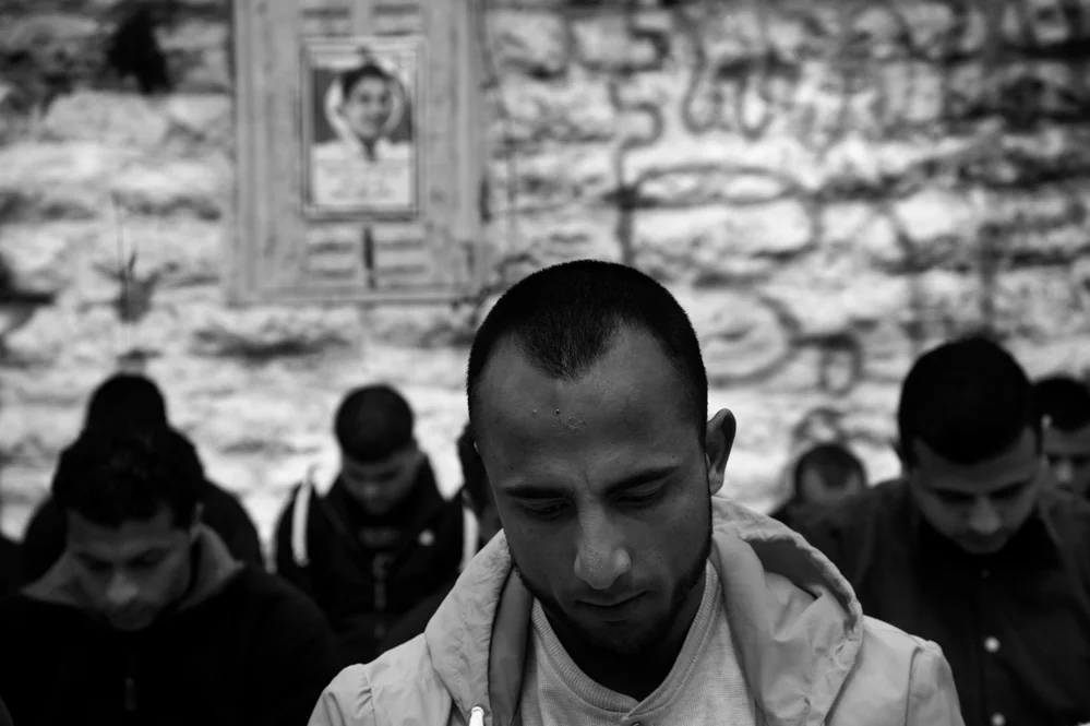  Friends pray at the funeral of Saji Sayel Darwish. Saji was shoot the night before after supposedly attacking Israeli soldiers on the road to Ramallah. Beitin; Palestinian territories. 11/03/2014 