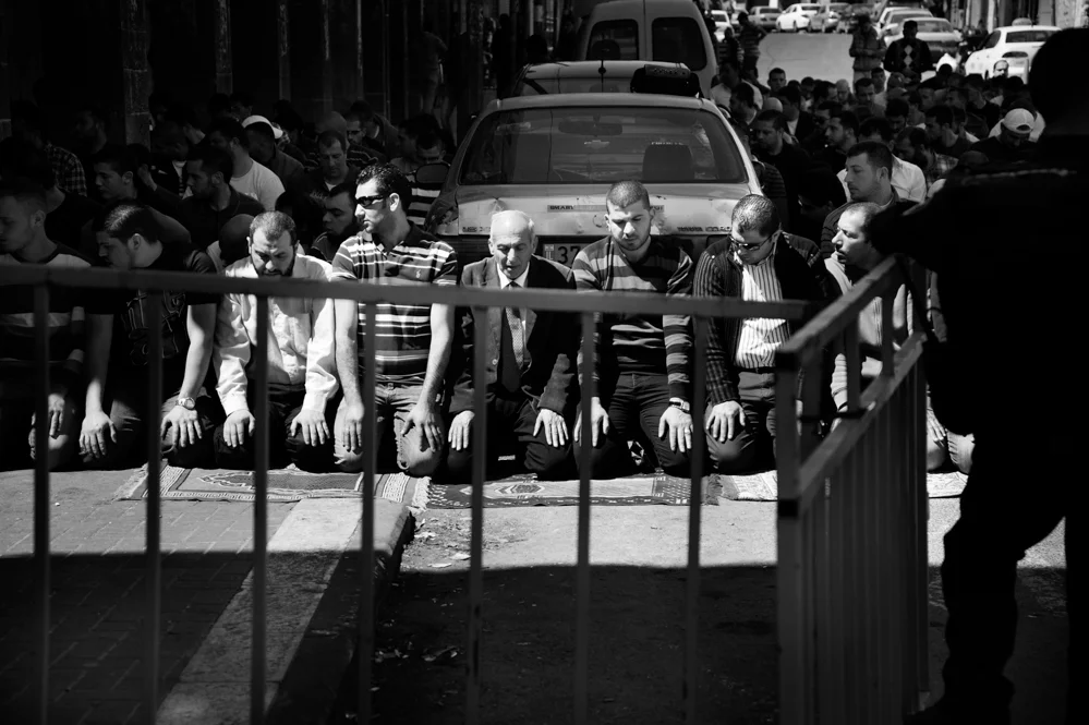  Palestinian performing the Friday prayers in front a Israeli check point at Herod's Gate during the entry restriction at the Al Aqsa Mosque 