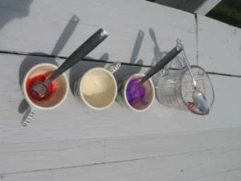 Step 3: The three tea cups of dissolved sodium alginate are colored as follows: red food dye (left), uncolored (middle), purple Crayola Kid's Paint (right).