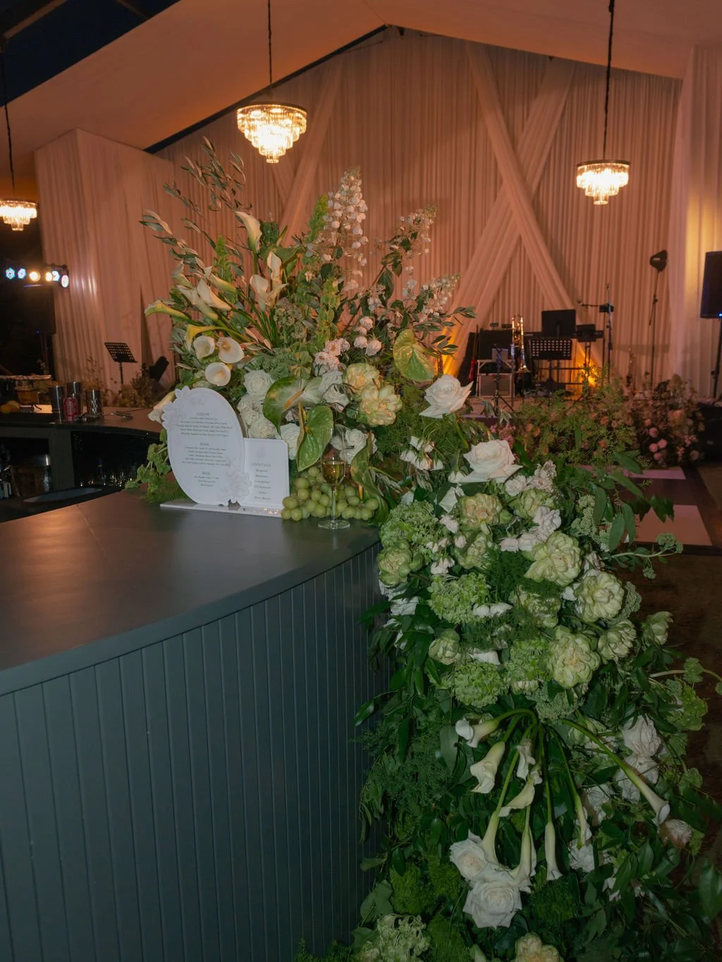 Wedding reception bar with cascading white floral installation