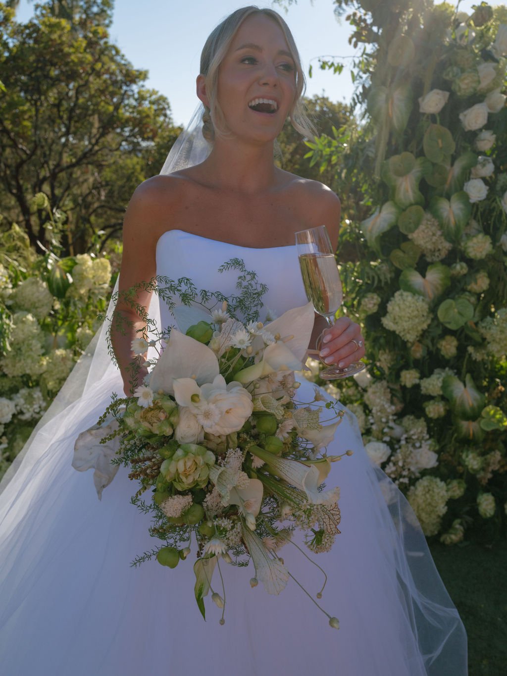 Bride with champagne and bouquet after the wedding ceremony