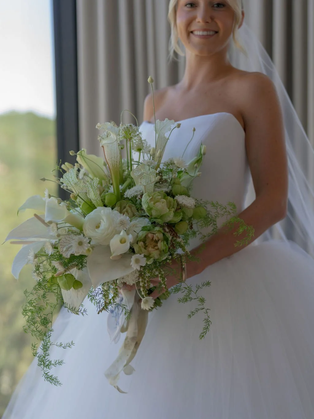 Bride holding a white and green calla lily bouquet