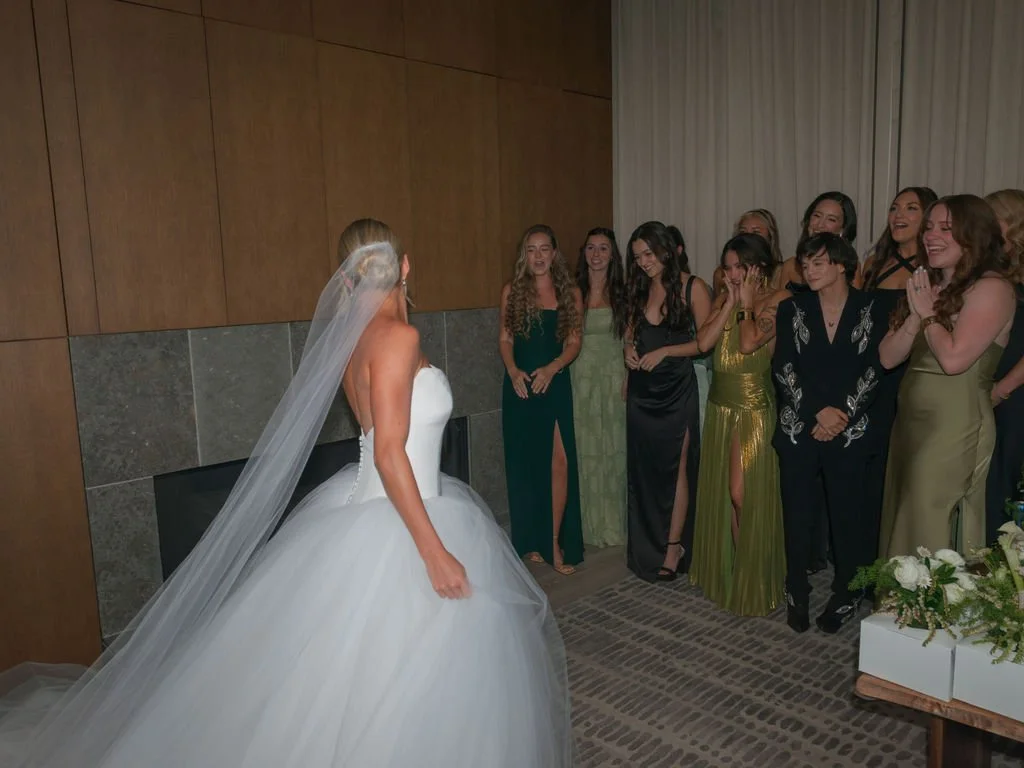 Bridesmaids' first look at the bride in her gown and veil in Harvest Home