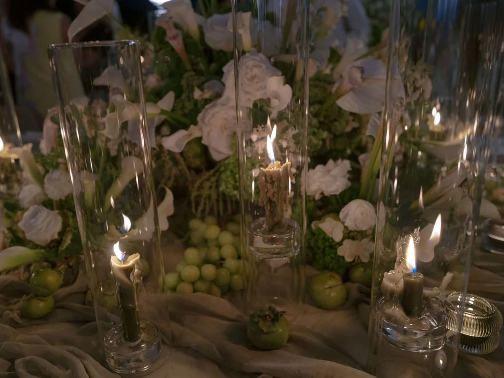 Candlelit wedding centerpiece with taper candles and green grapes