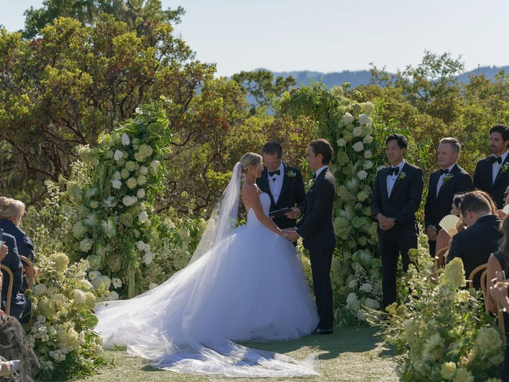 Wedding vows at a white floral arch at Montage Healdsburg