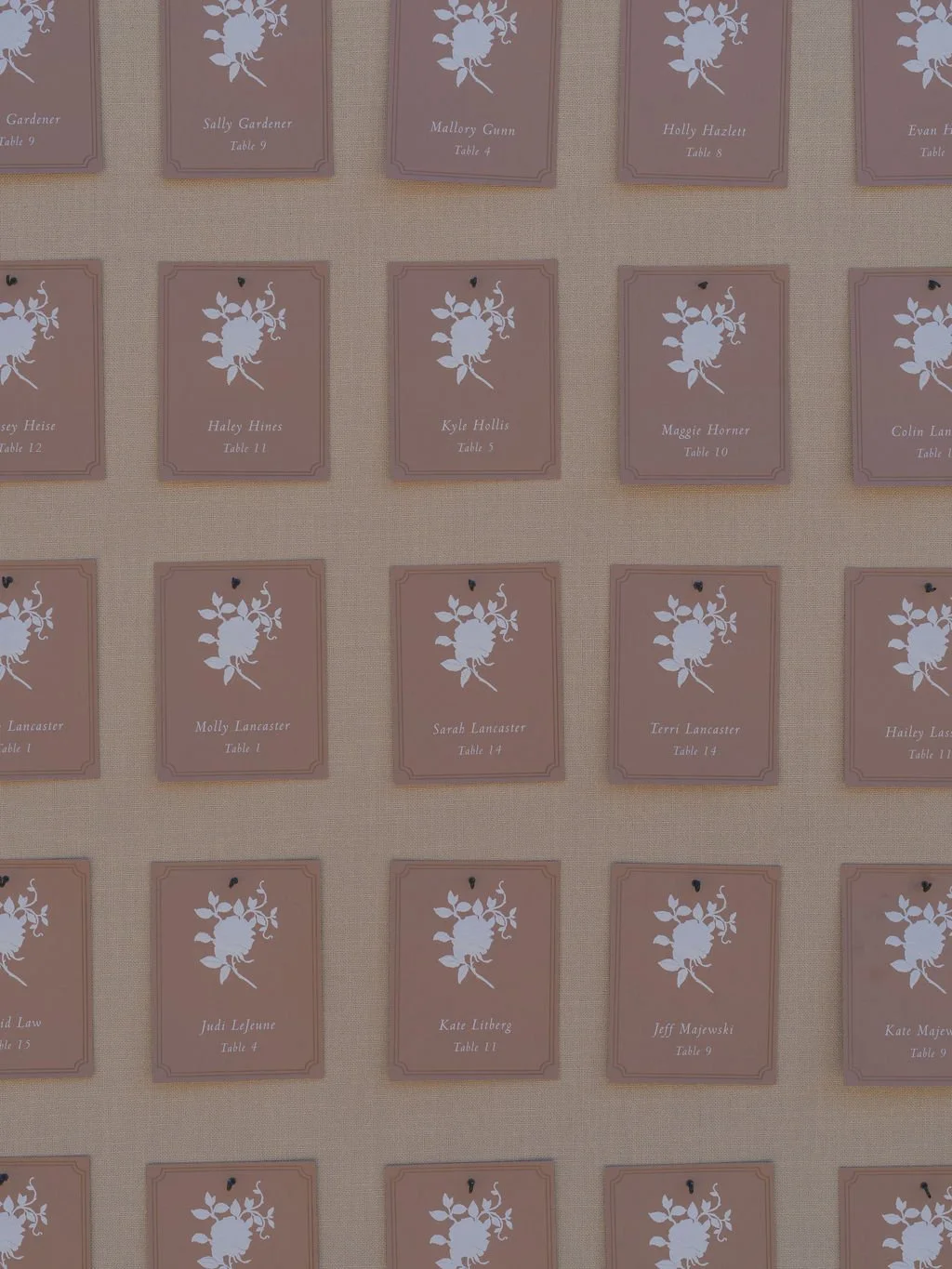 Rose-colored wedding escort cards with floral motif