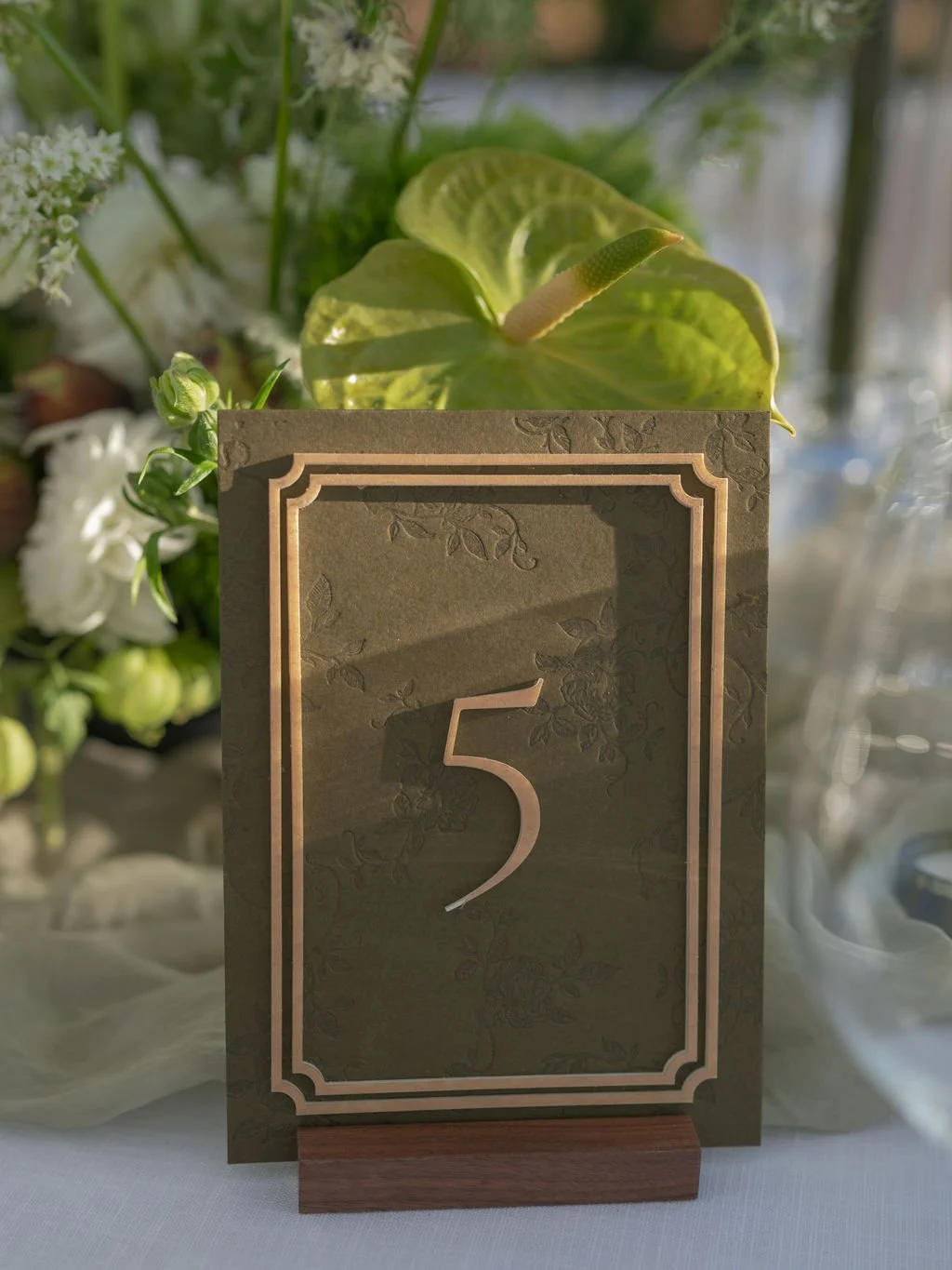 Olive and gold wedding table number with green anthurium