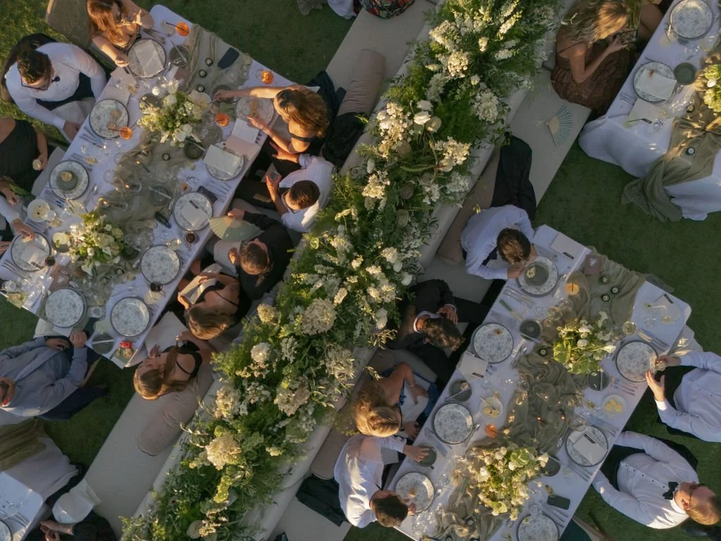 Overhead view of long wedding reception dinner tables with floral hedge