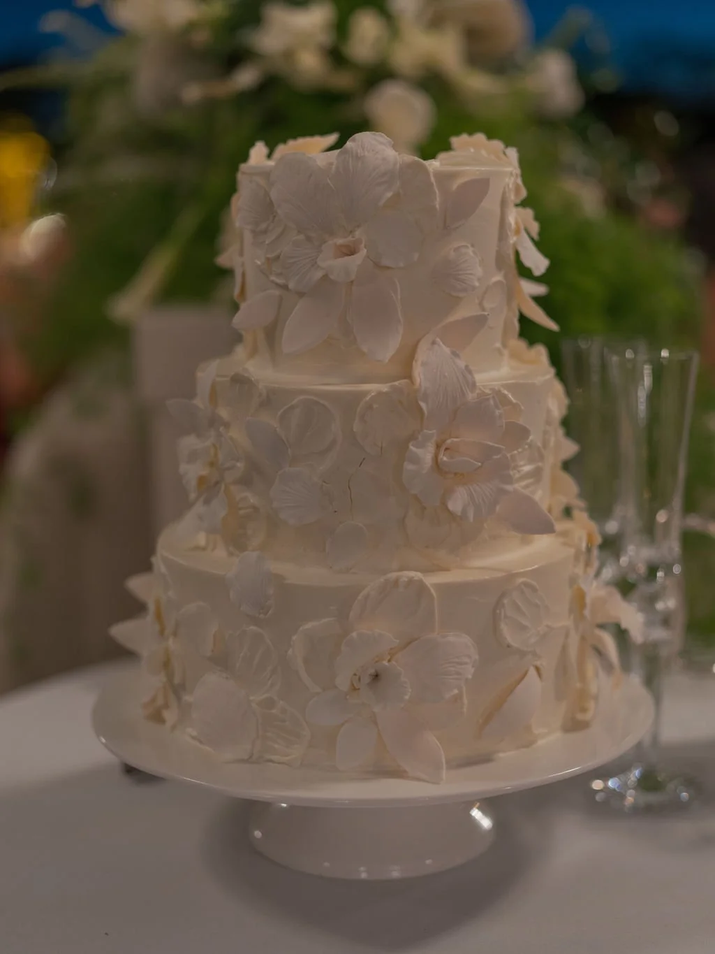 Three-tier white wedding cake with sugar flowers
