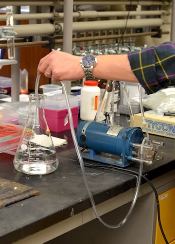 Pumping water samples through a filter for solid state extraction.