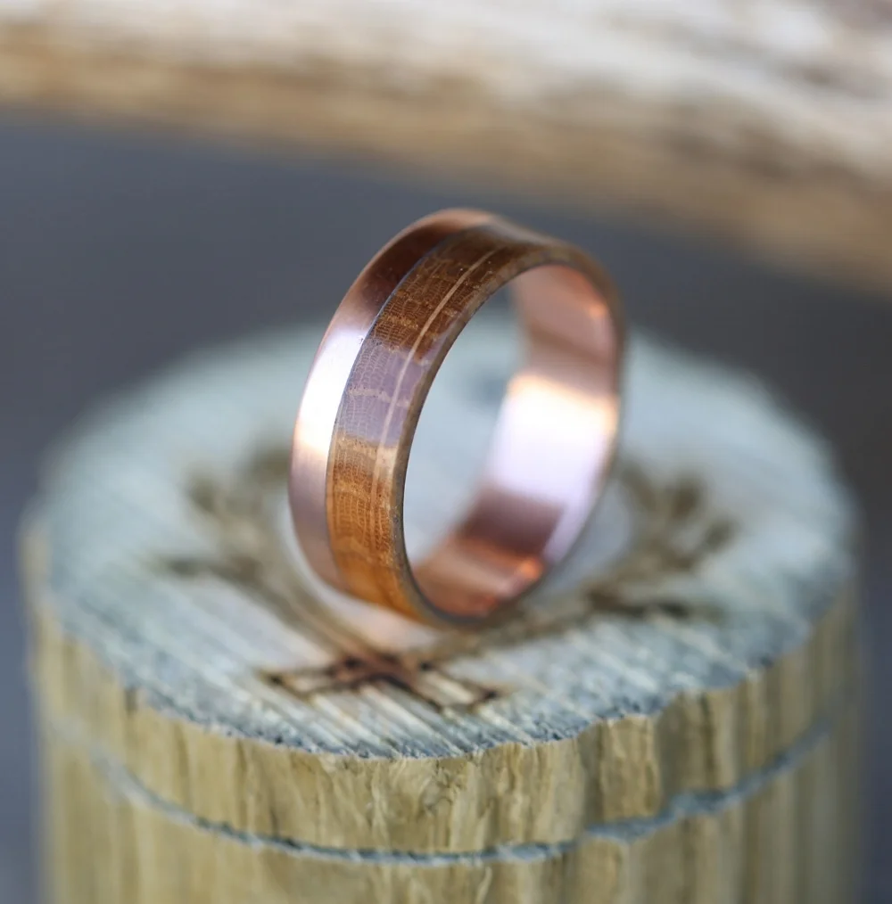 Men's rose gold wedding band featuring whiskey barrel wood. Handcrafted by Staghead Designs.
