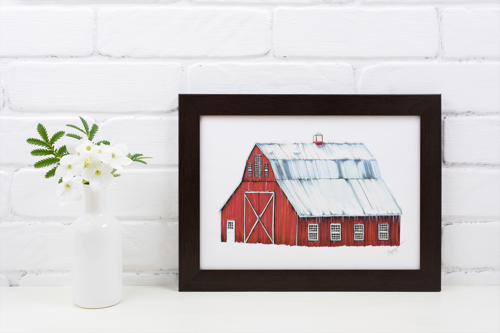 red barn fine art print in black frame sitting on table