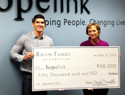 Tony Bacon of the Bacon Family Foundation presents a check to Hopelink CEO Marilyn Mason-Plunkett