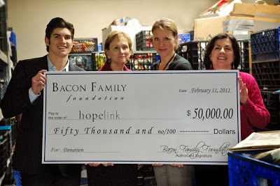 Tony Bacon from The Bacon Family Foundation presents a check to Hopelink CEO 