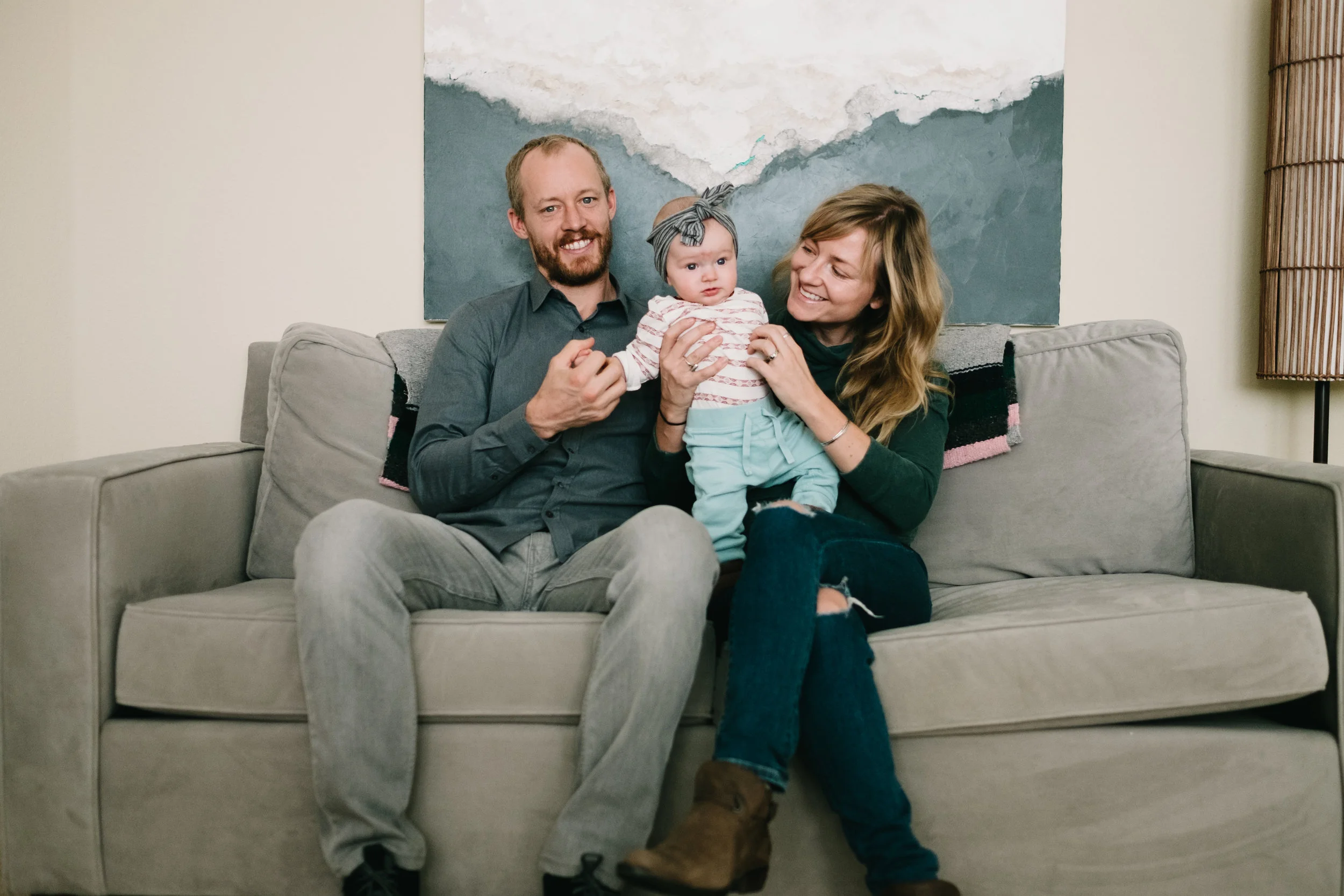 Family of three sitting on couch