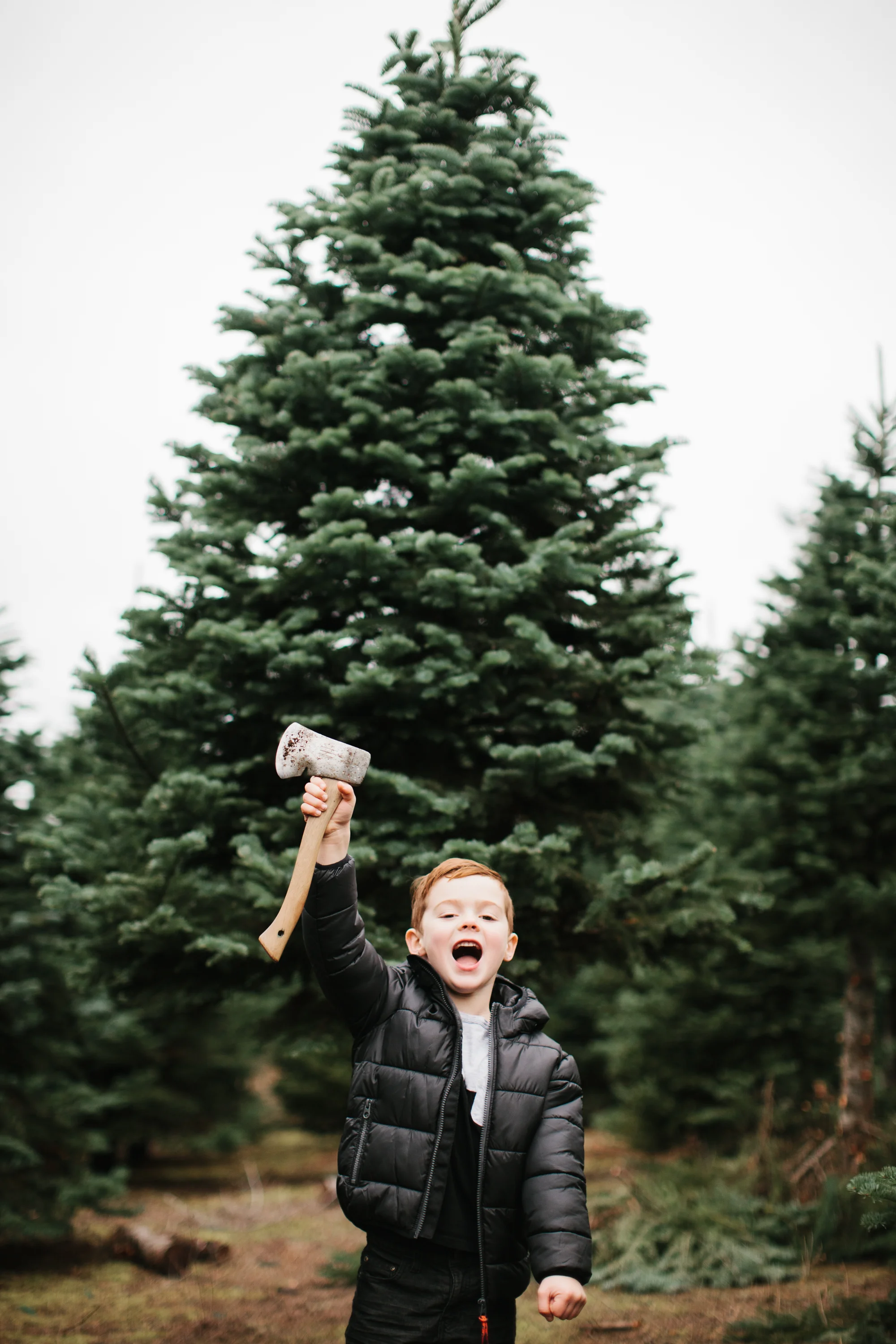 young boy holding up axe