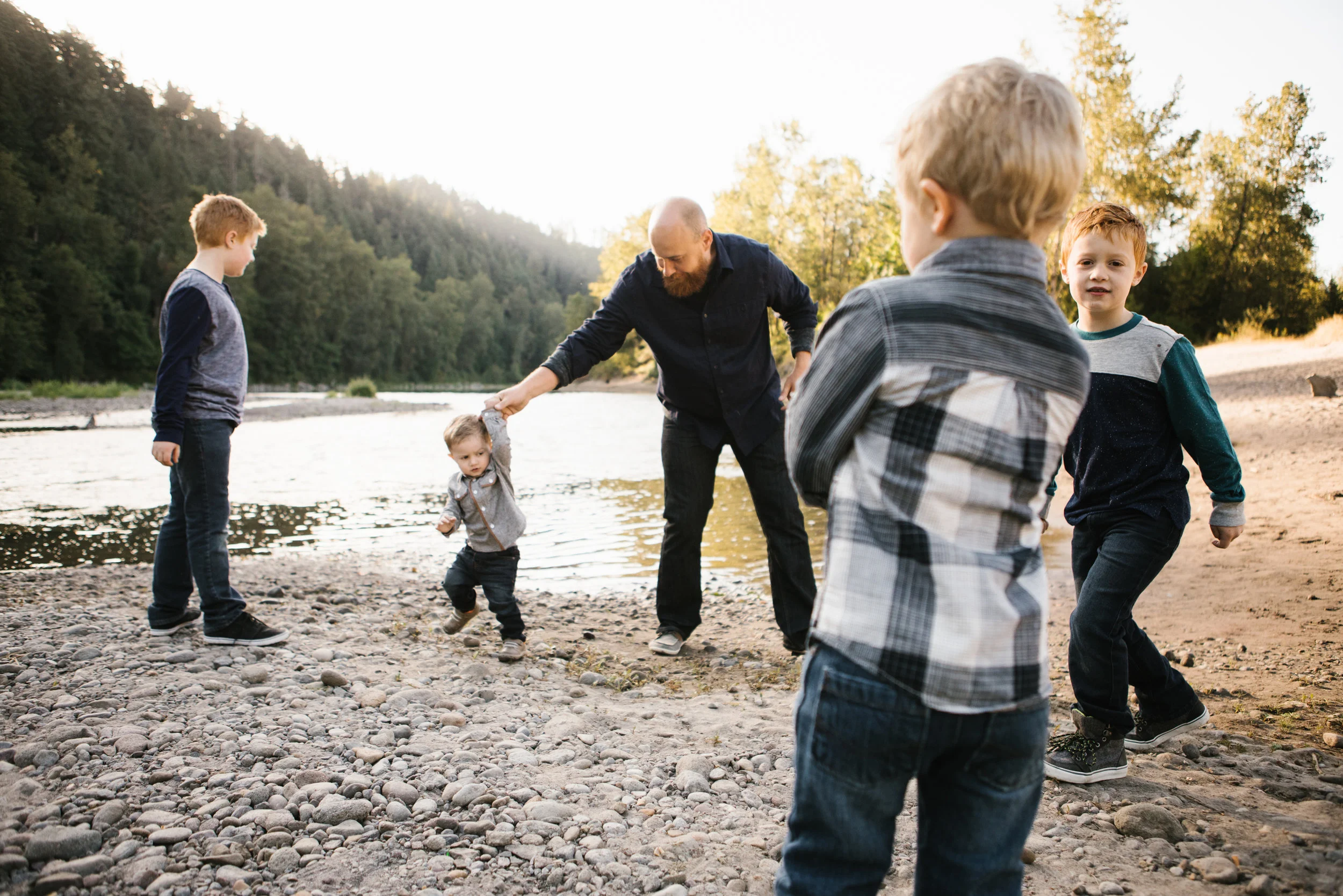 Dad with four boys playing by river