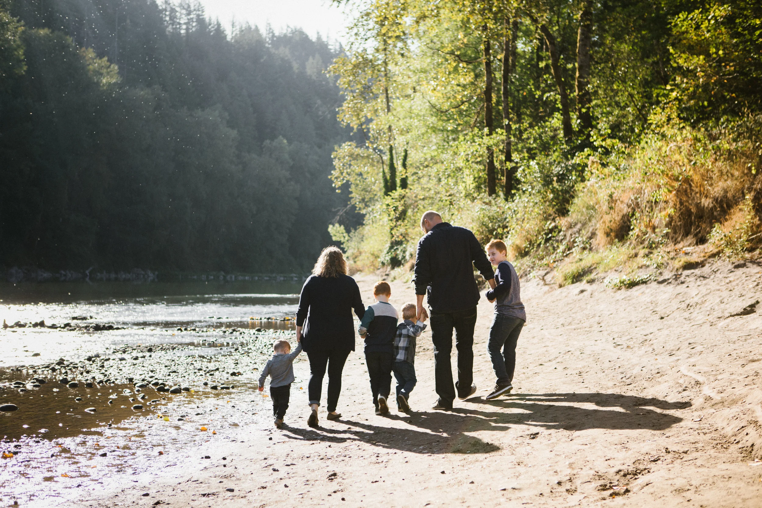 Family of six walking by river