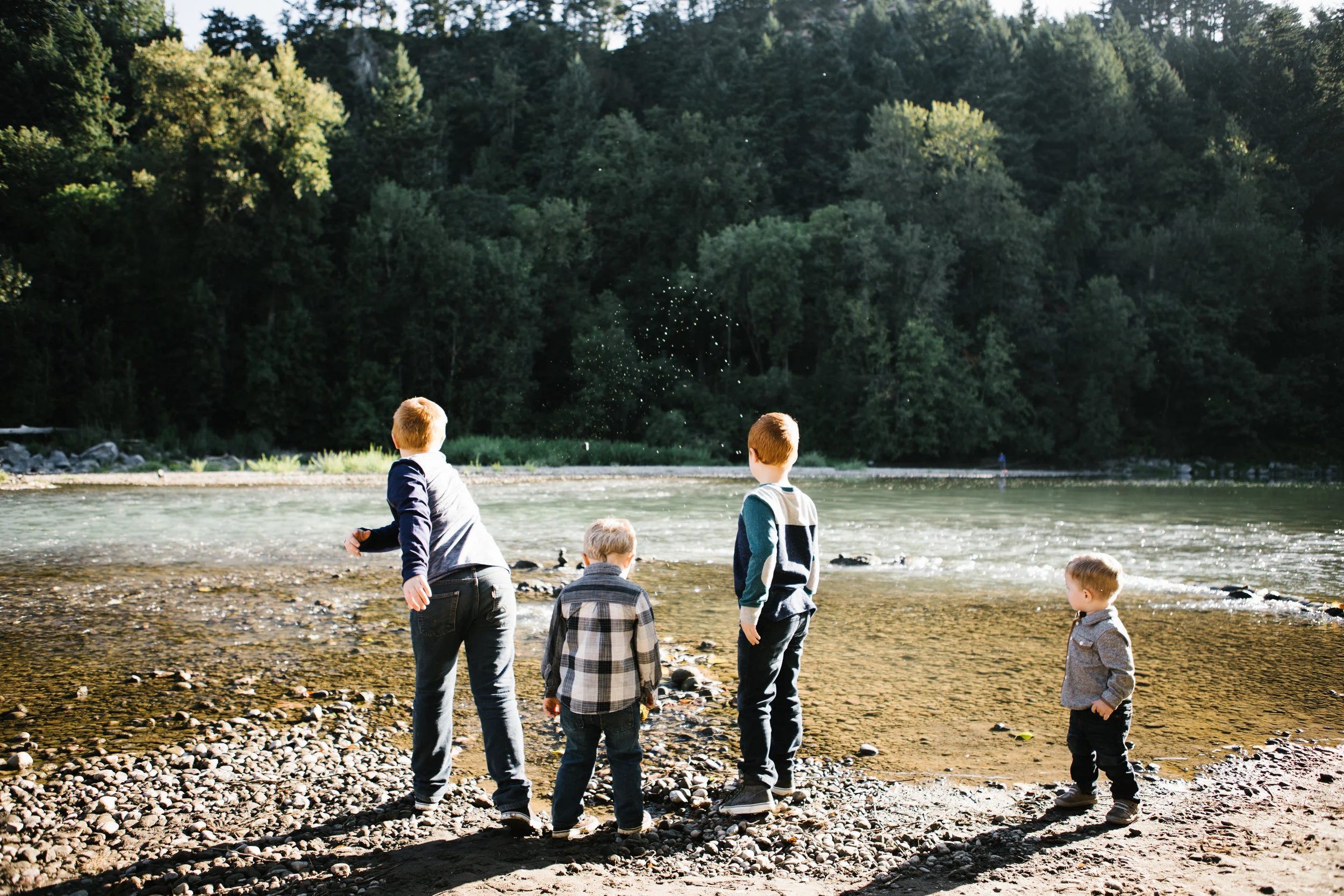 Four young brothers playing by river