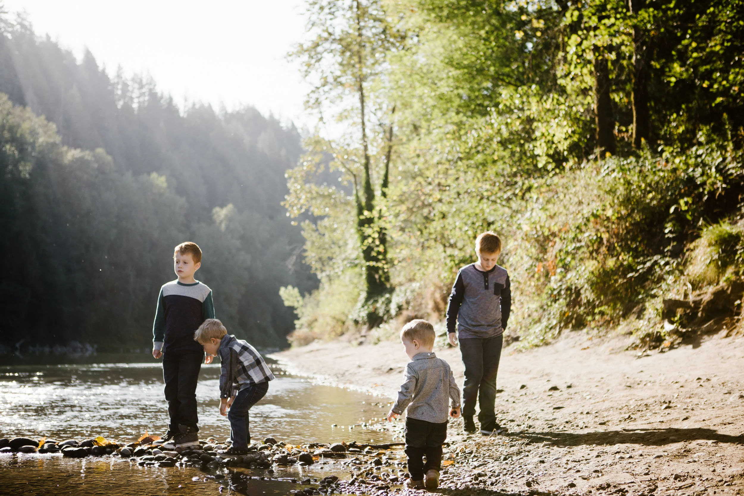 Four young brothers playing by river