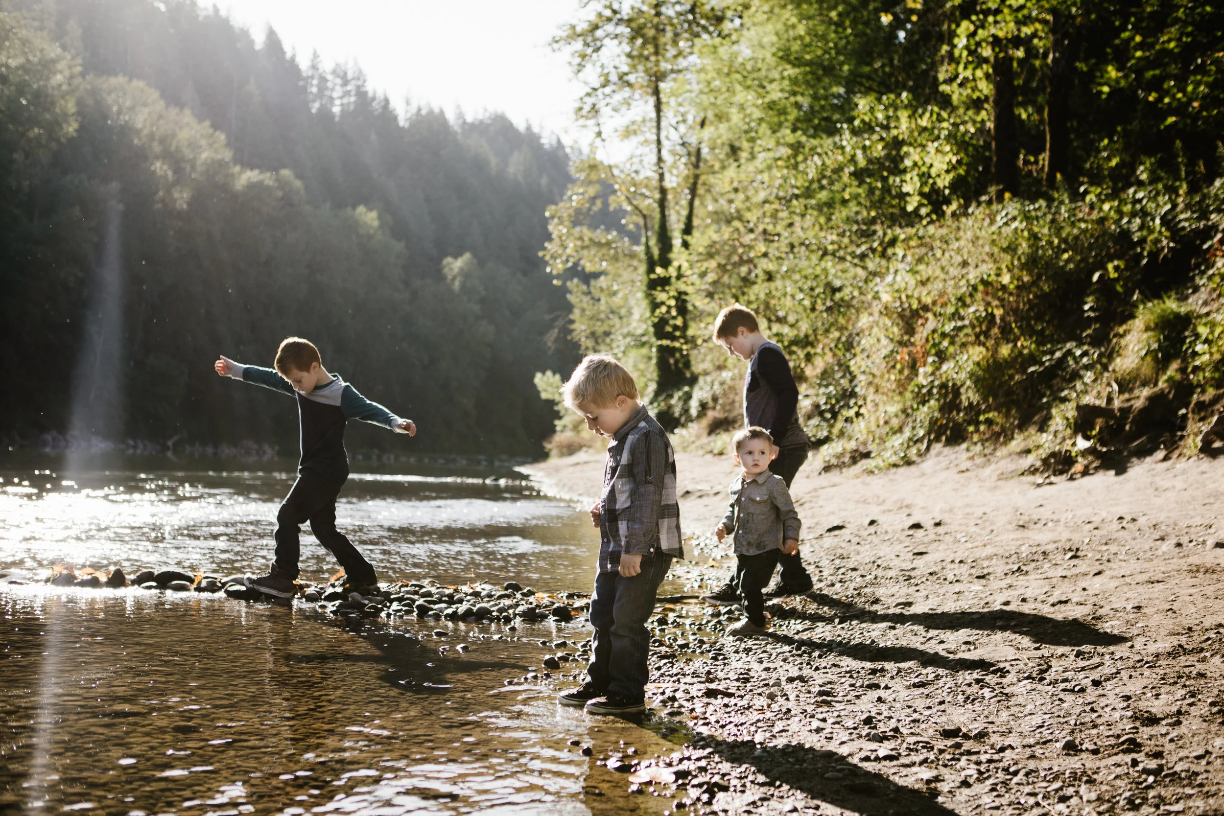 Four young brothers playing by river