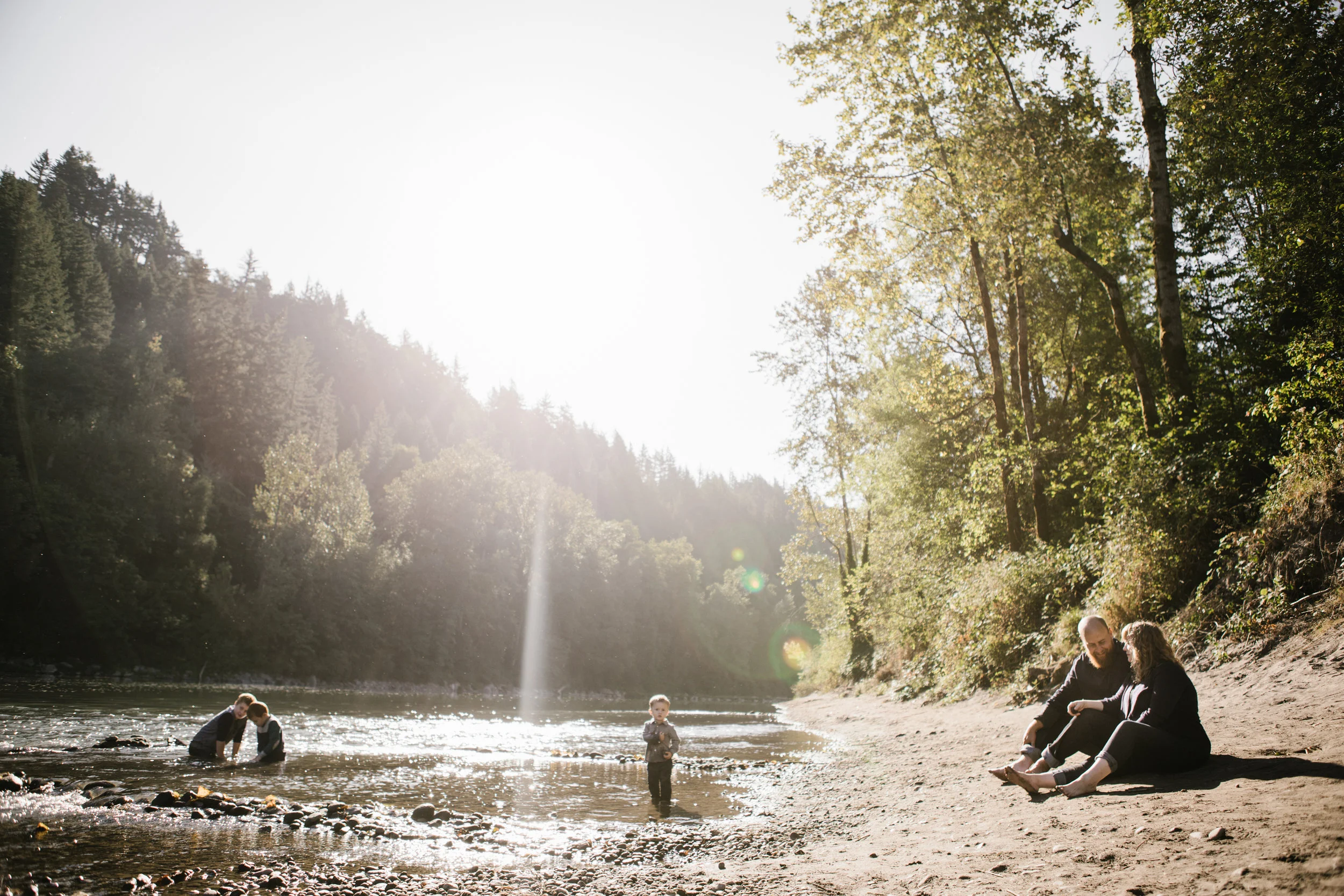 Young family playing by river