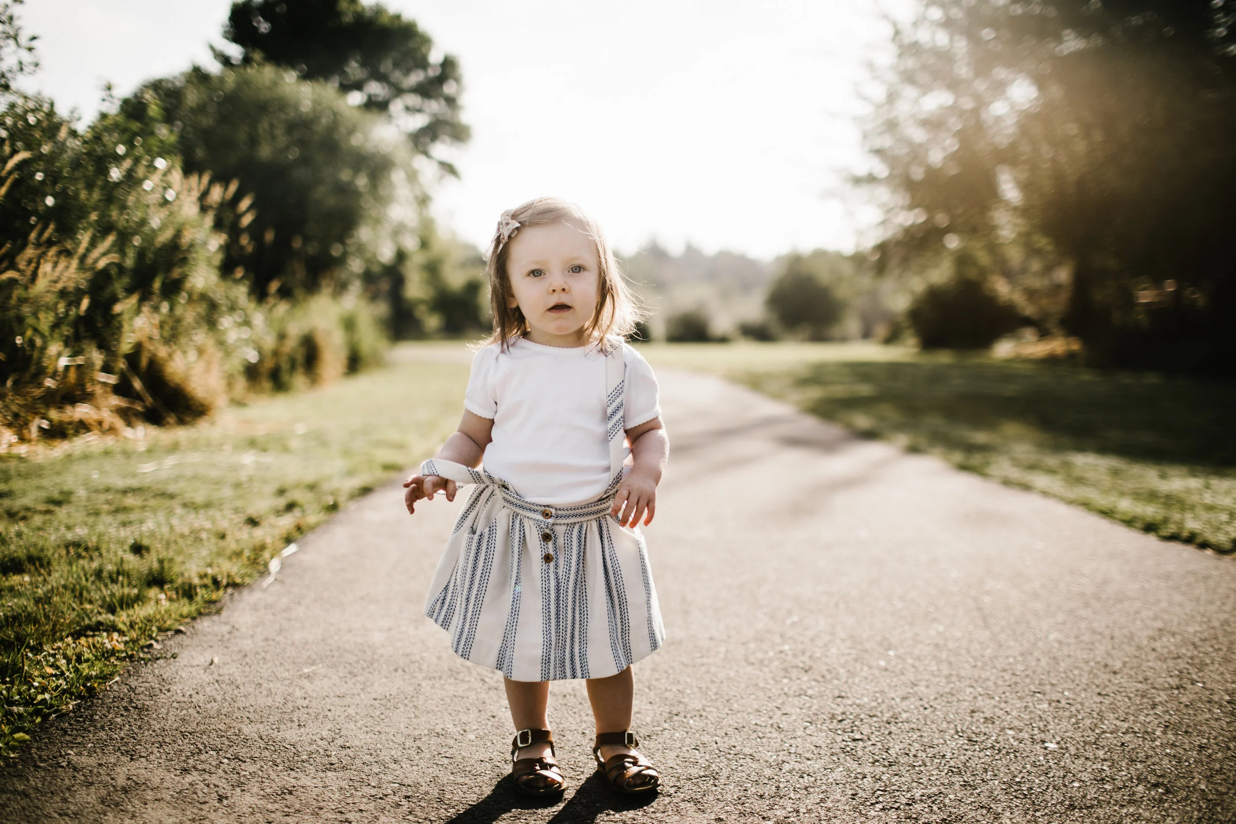Toddler girl on path looking at camera