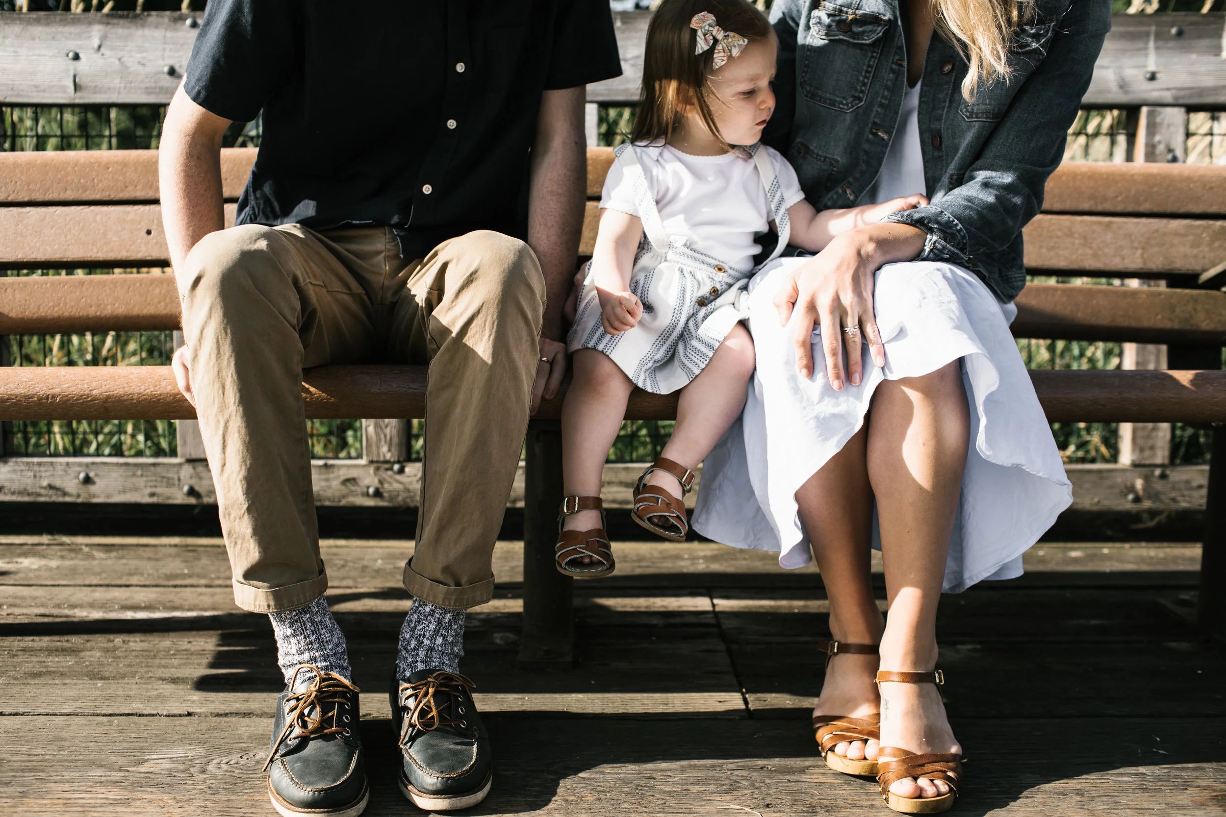 family of three sitting on bench