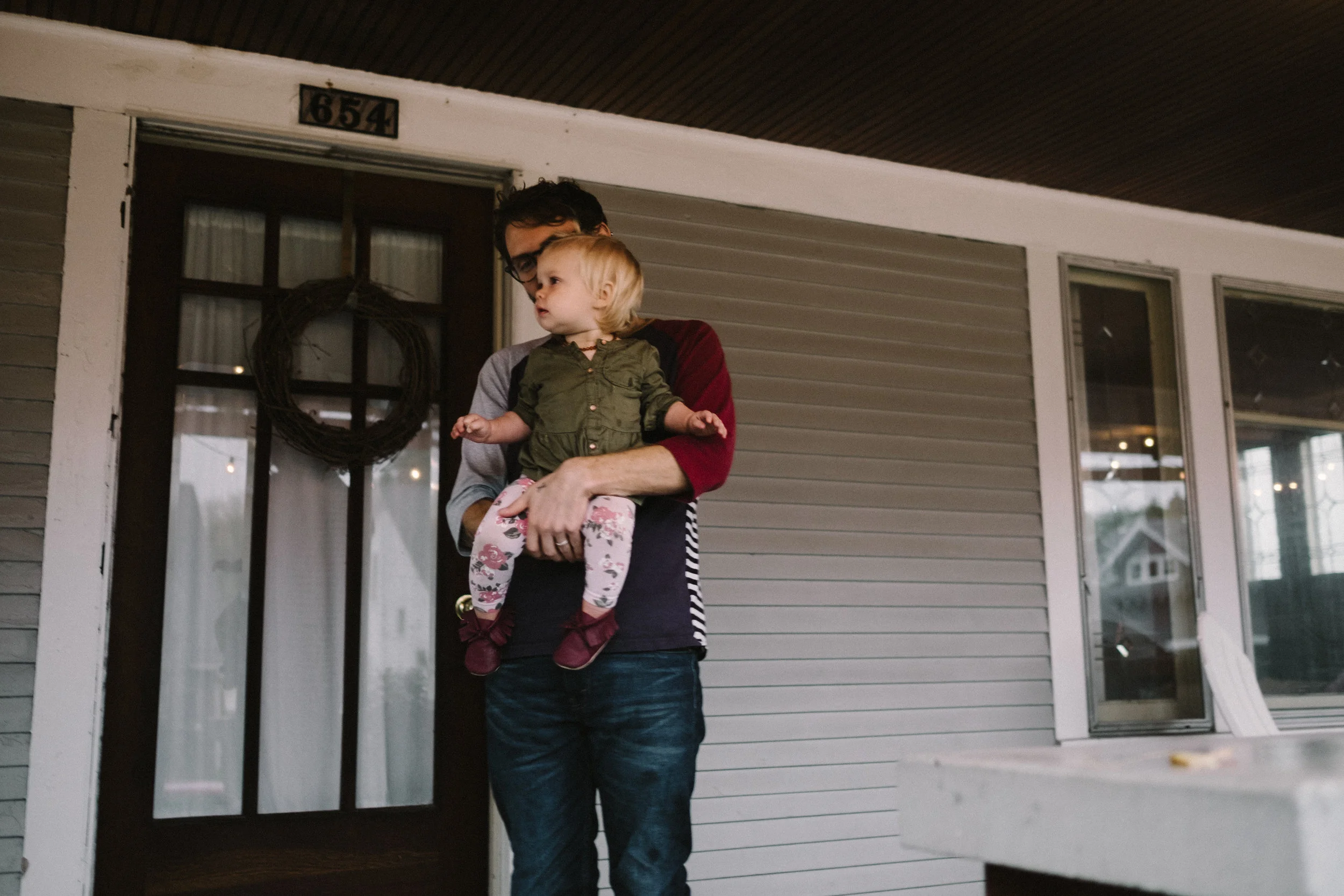 dad holding daughter on porch