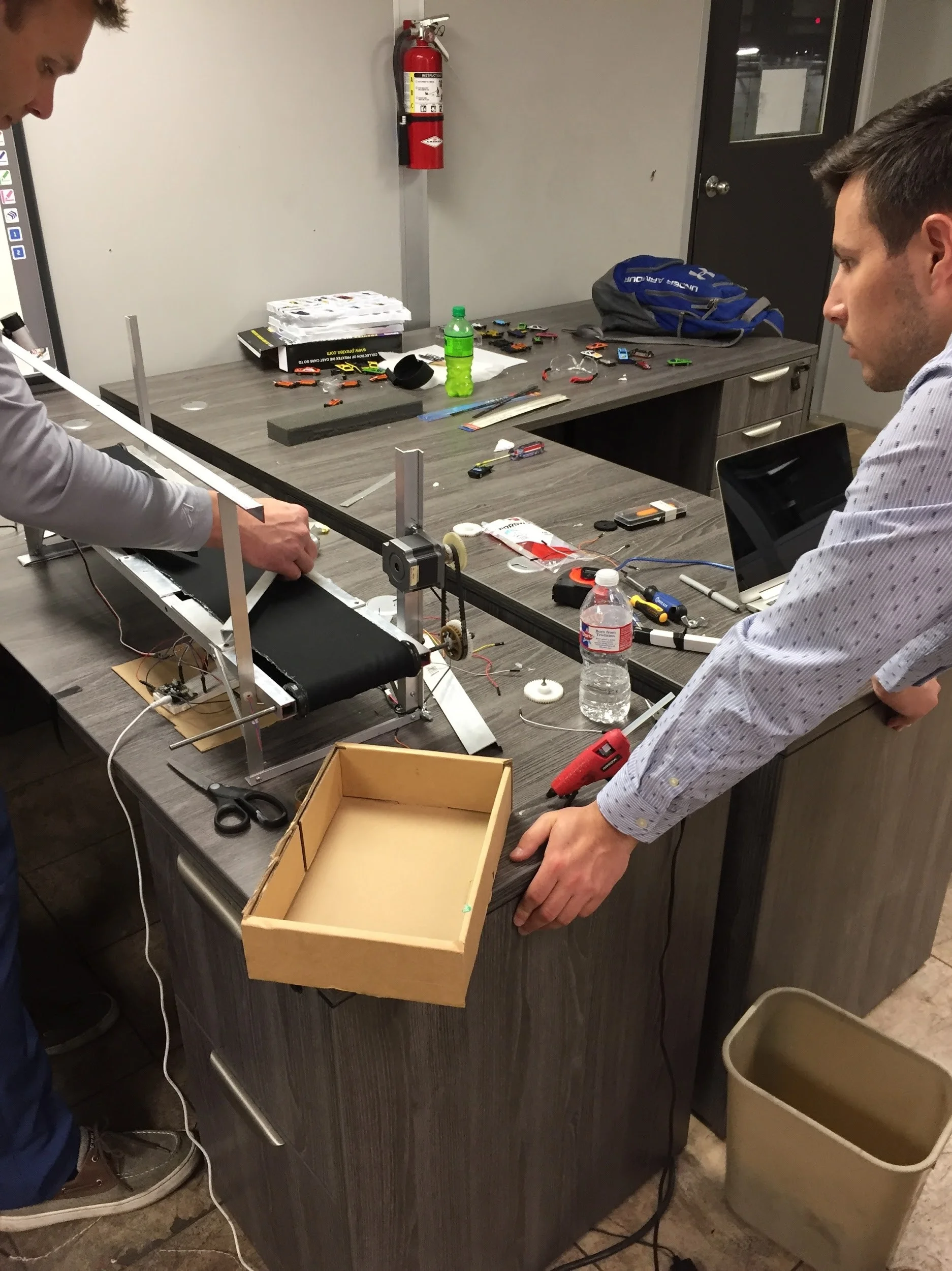 Allen and Hall work on a conveyor belt prototype. The software they are building will assist in identifying and sorting brake shoes upon receipt at SRCL’s facilities.