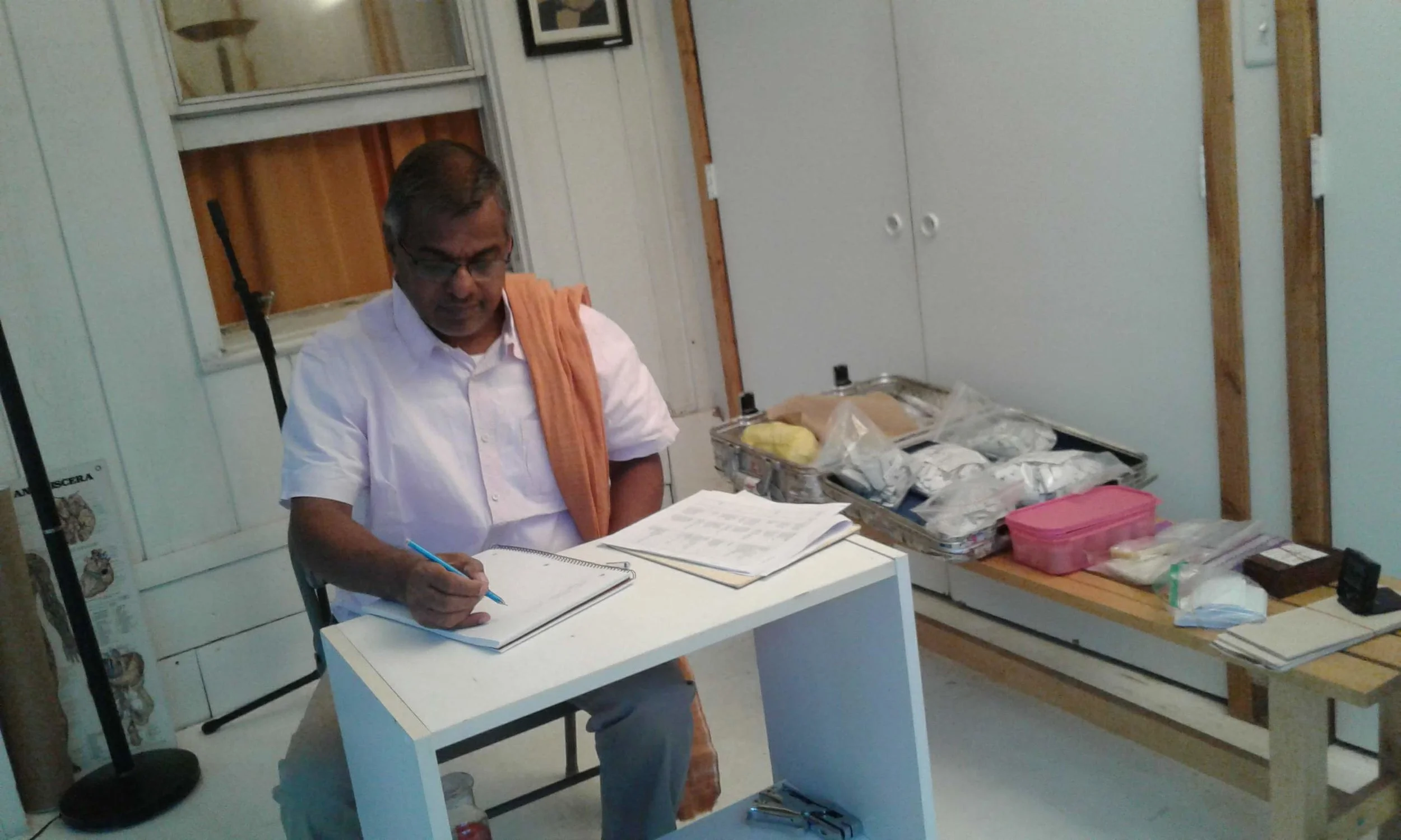 The Vaidyan Making Consultation Notes at the Ashram