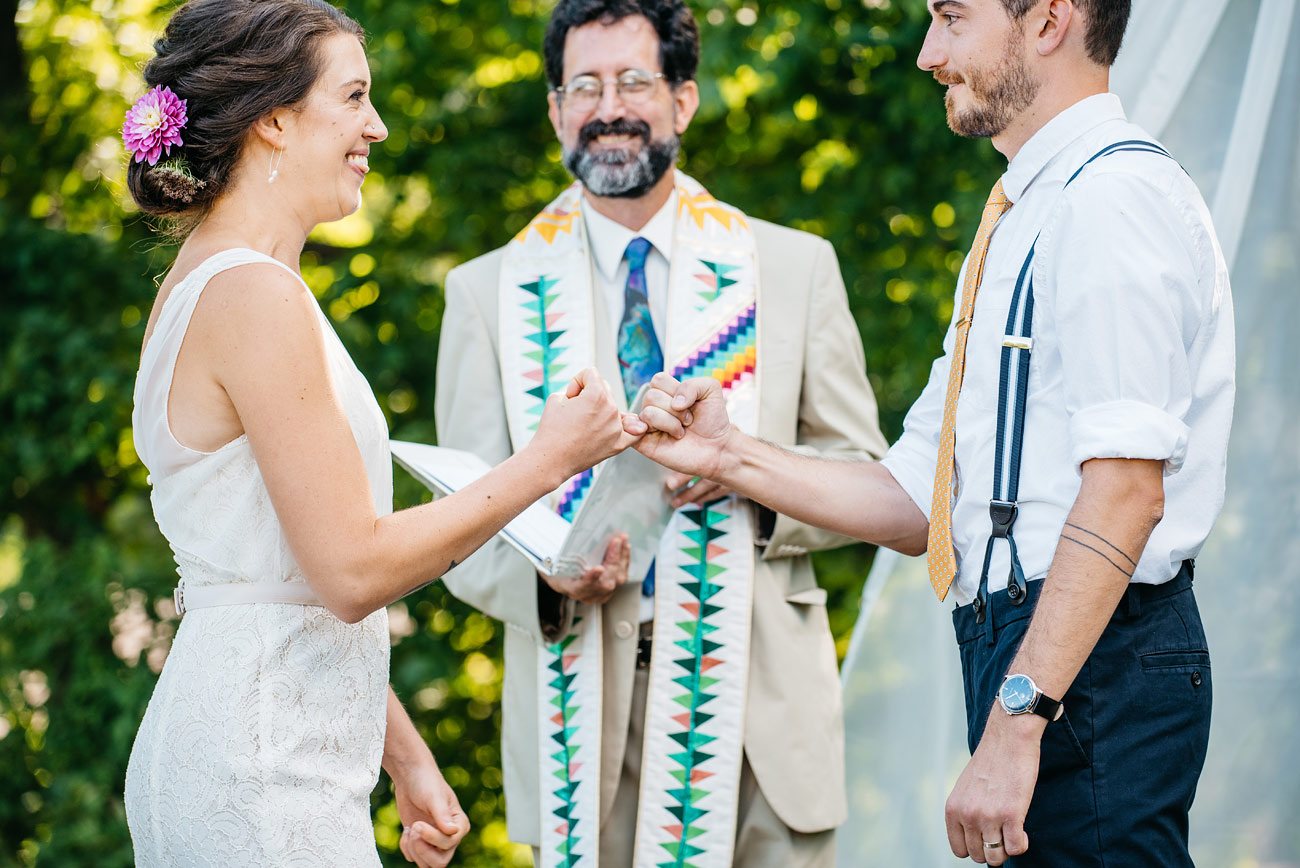 bride and groom pinky swear during their backyard new england ceremony creative and fun wedding photography